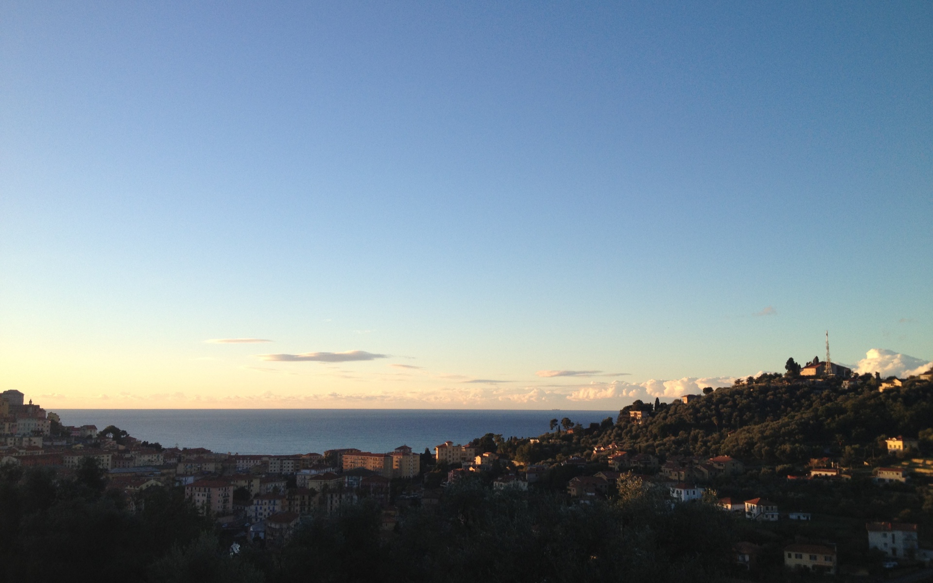 Закат над городом на курорте Империя, Италия