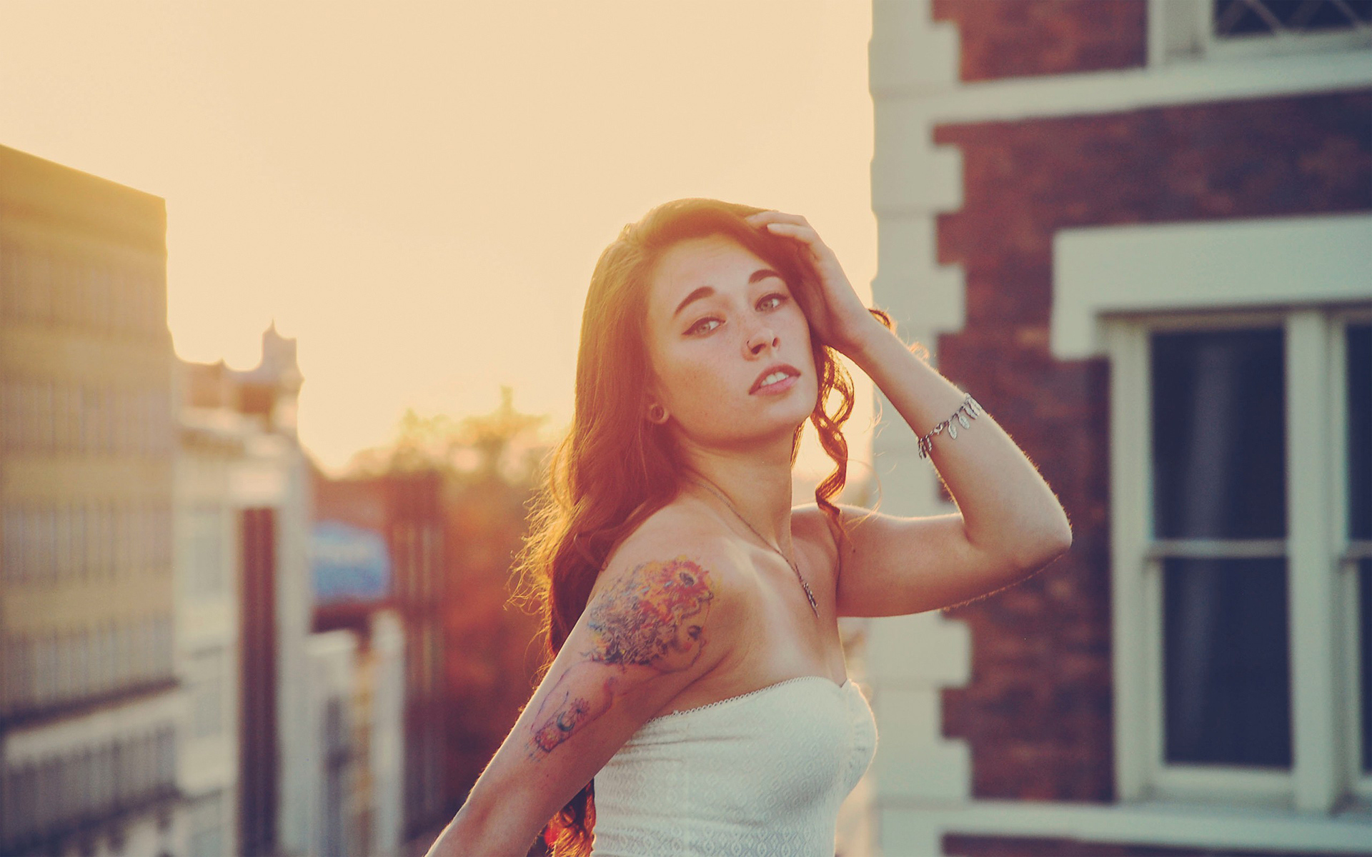 Girl at sunset with a tattoo on his shoulder