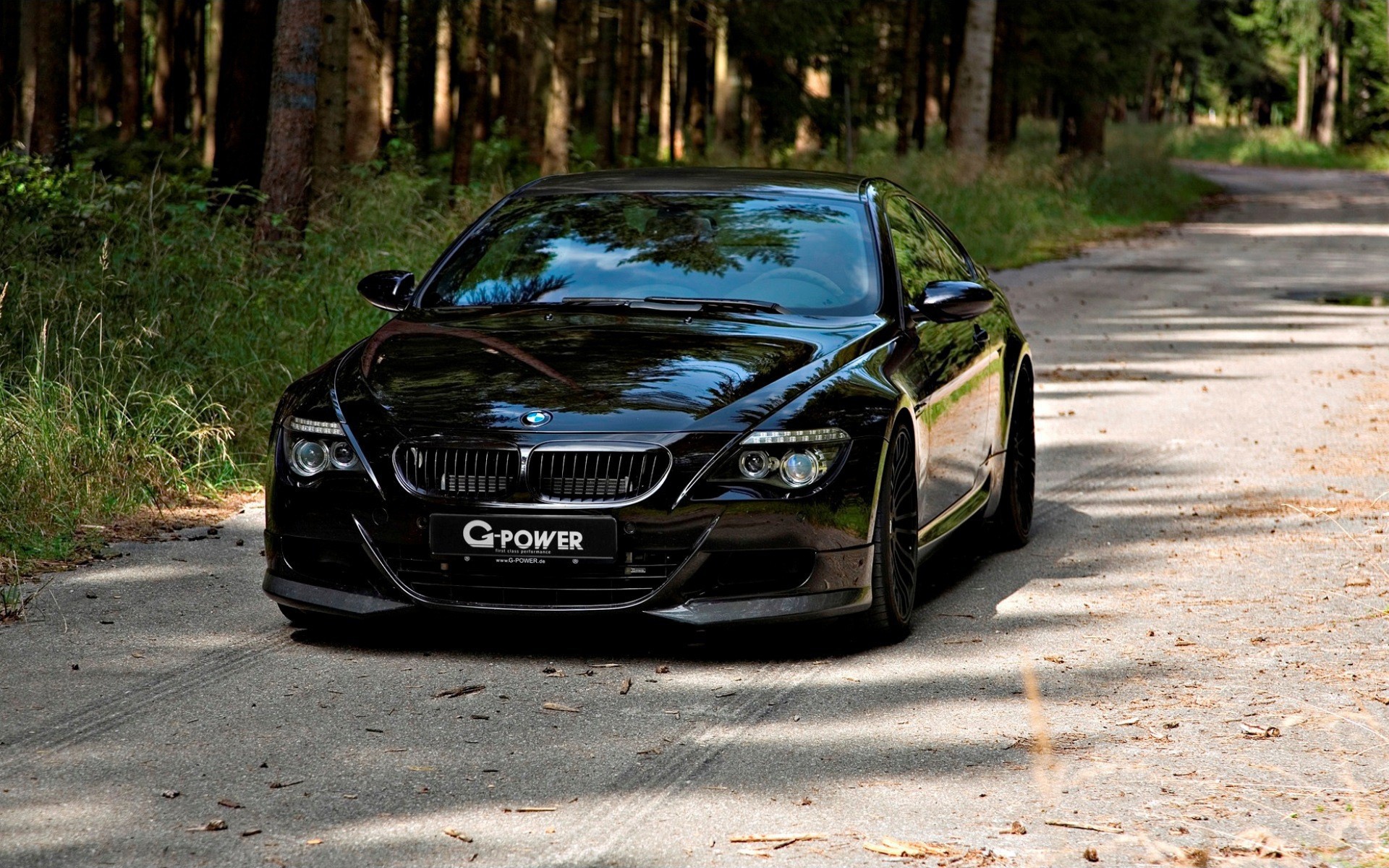 Черный BMW M6 Hurricane RR на проселочной дороге в лесу