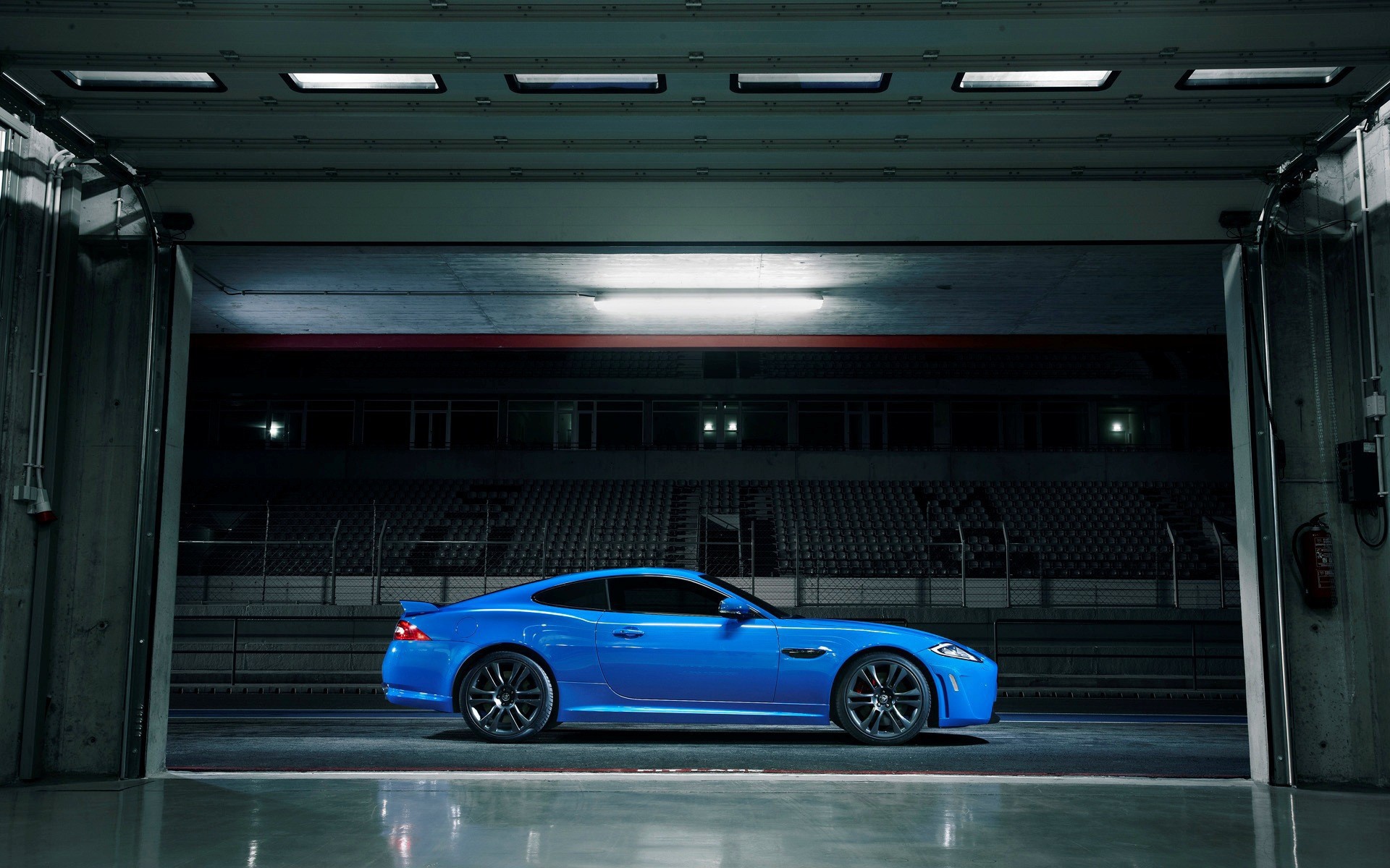 Голубой Jaguar XKR-S на стадионе