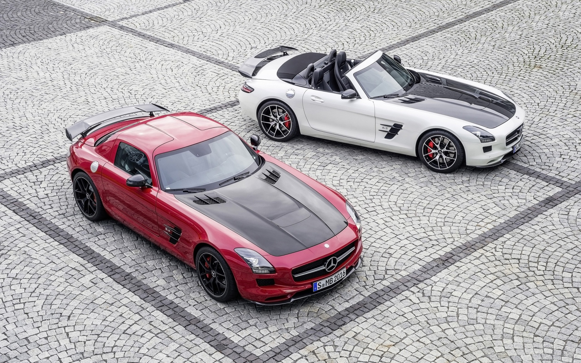 Красный и белый Mercedes-Benz SLS AMG на брусчатке
