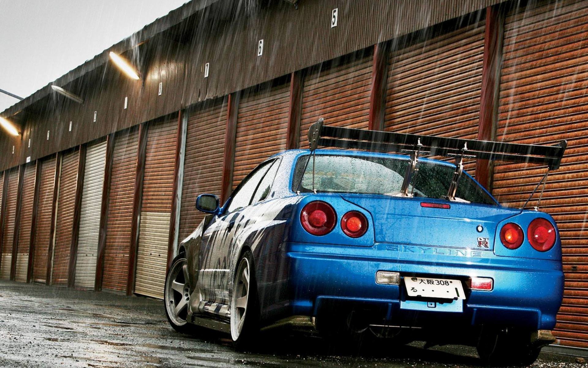 Синий Nissan Skyline GT-R R34 во время дождя