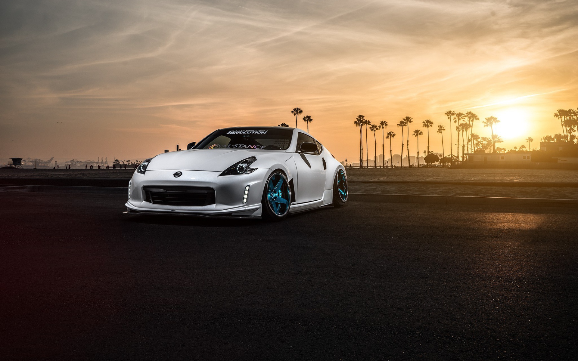Белый Nissan 370Z на фоне пальм и заката