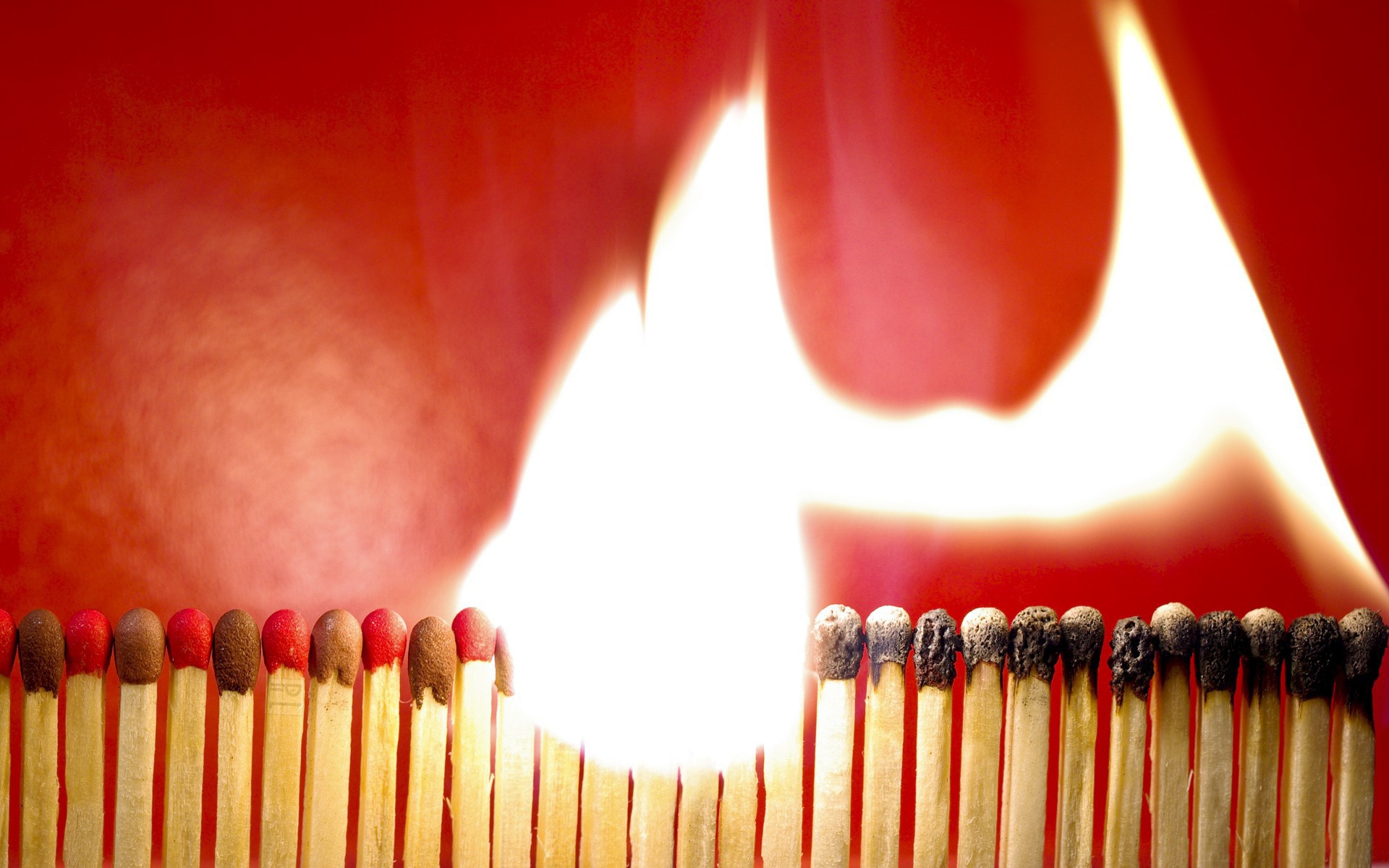 Горящий ряд спичек на красном фоне