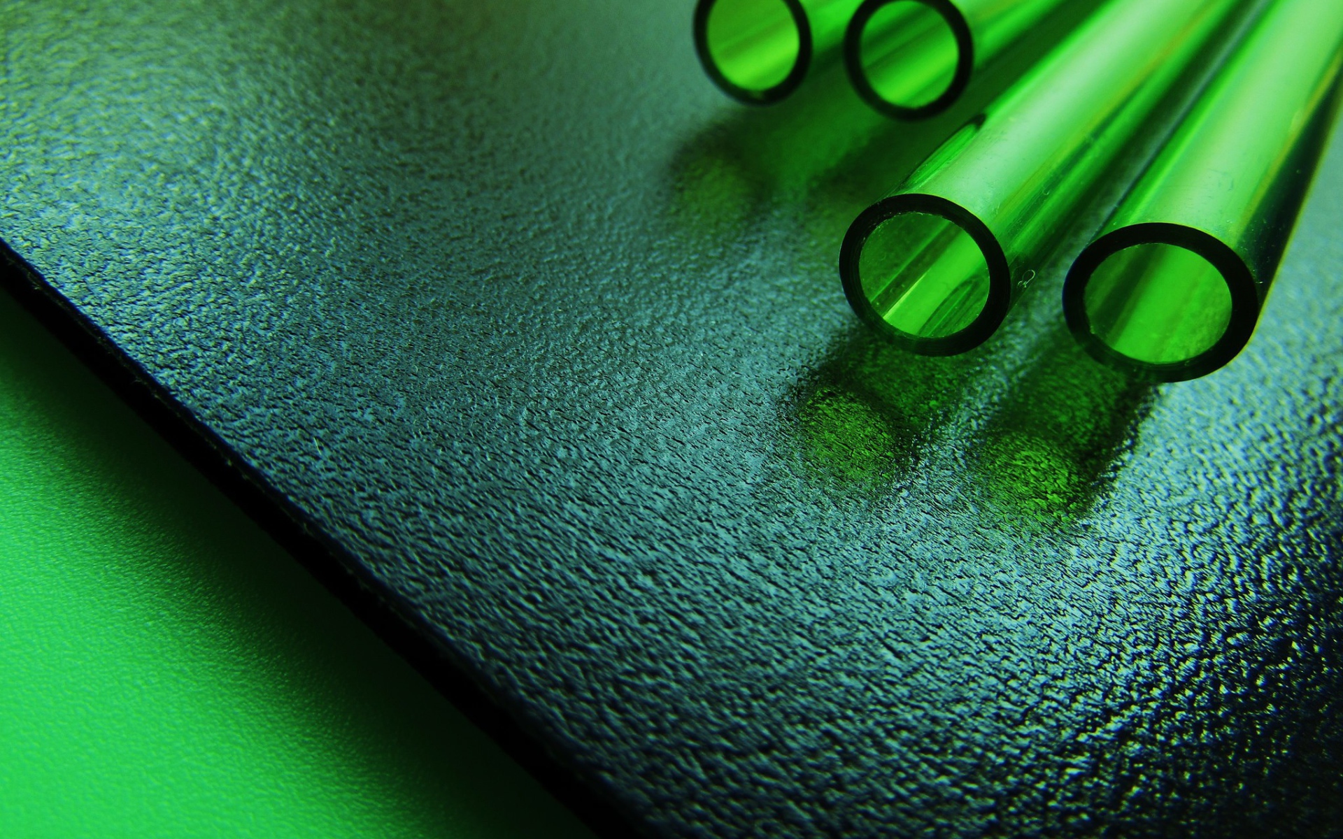 Трубки из зеленого стекла на черной плите