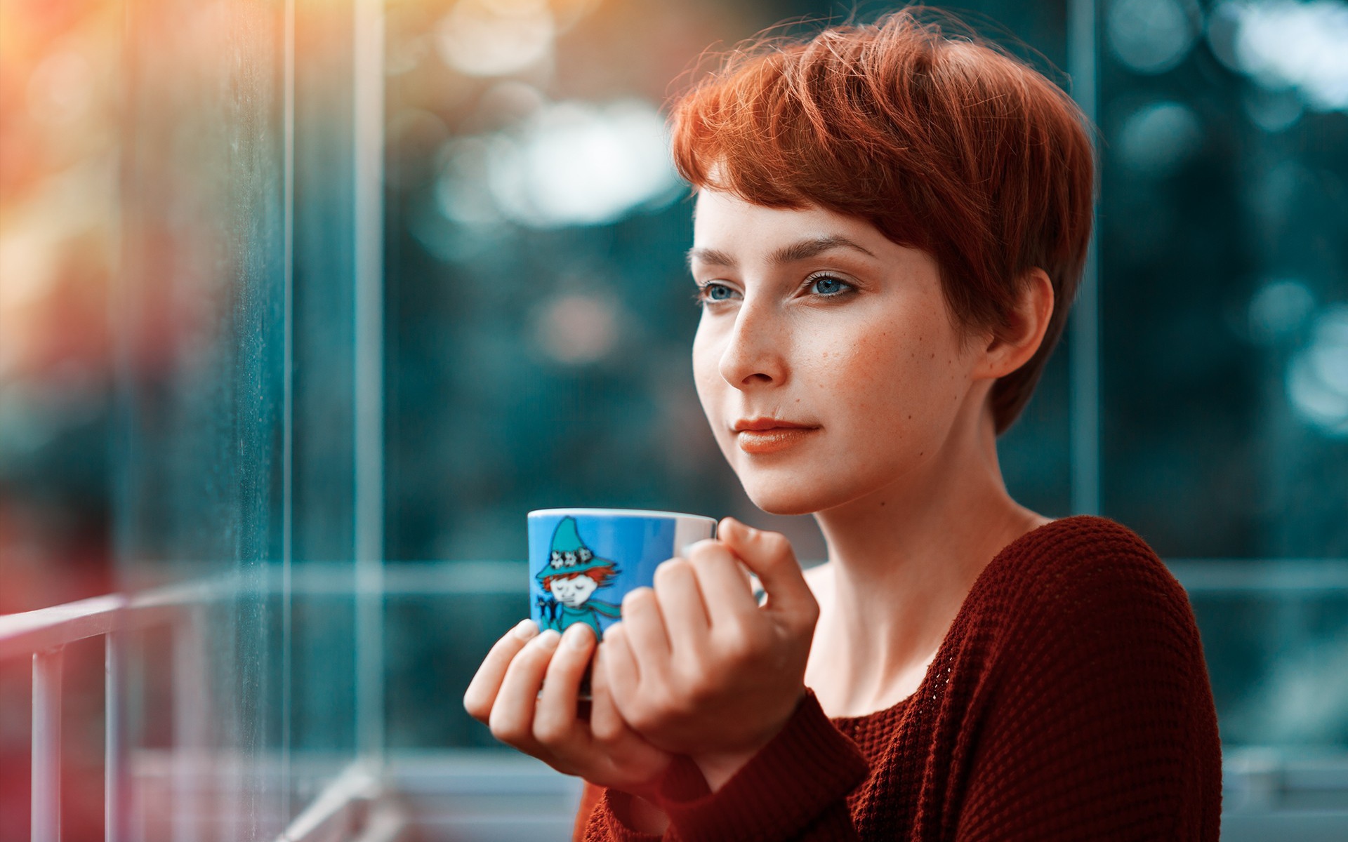 Девушка с короткими волосами пьет кофе