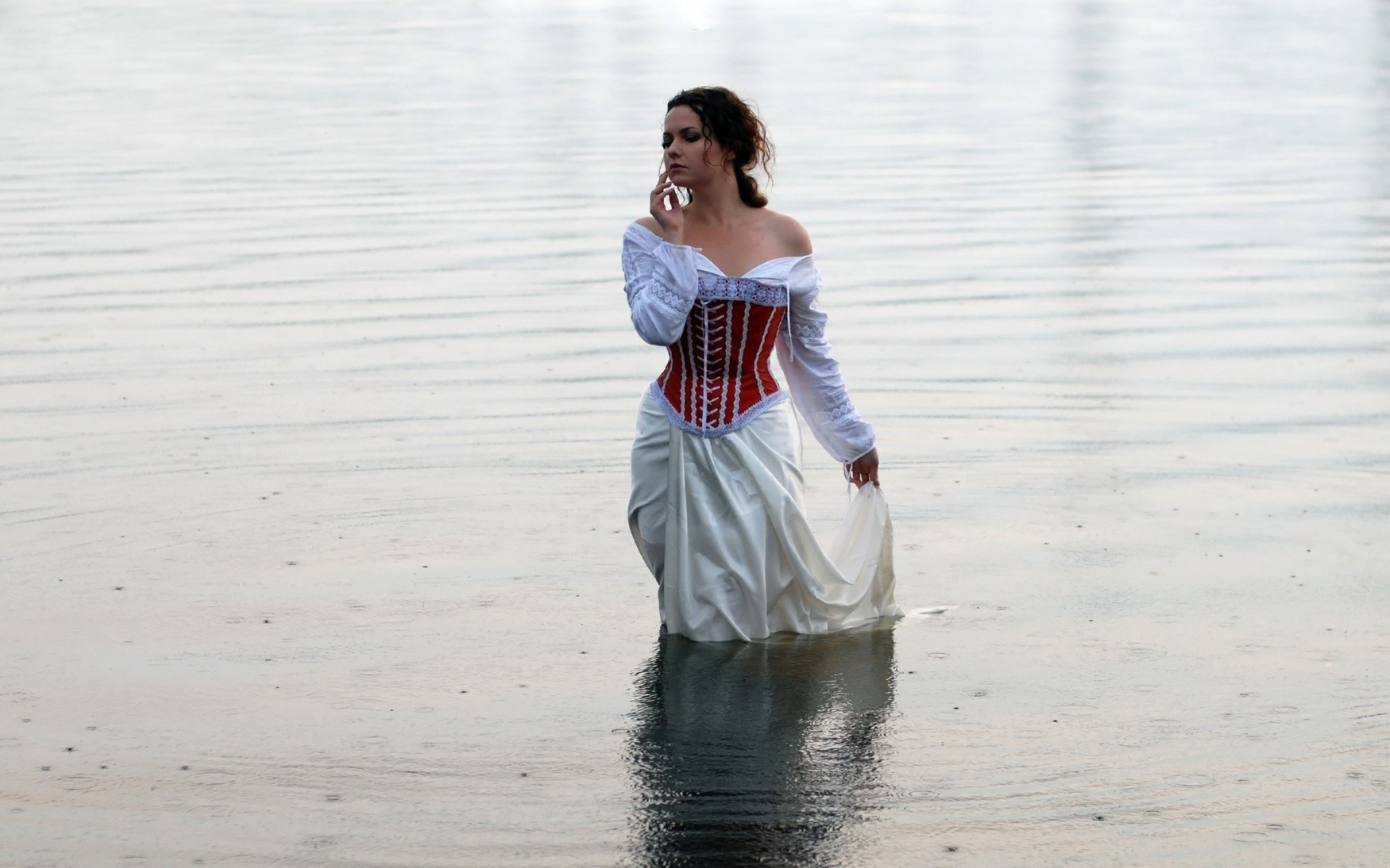 Girl in white dress standing in water