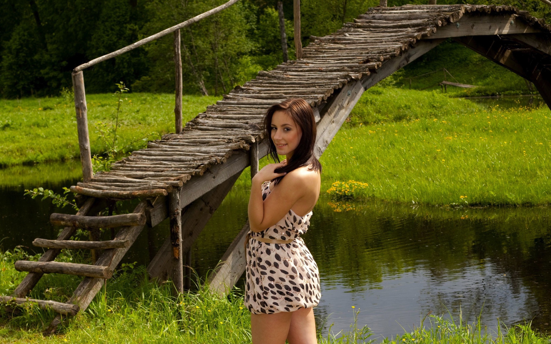 Девушка у деревянного моста через реку