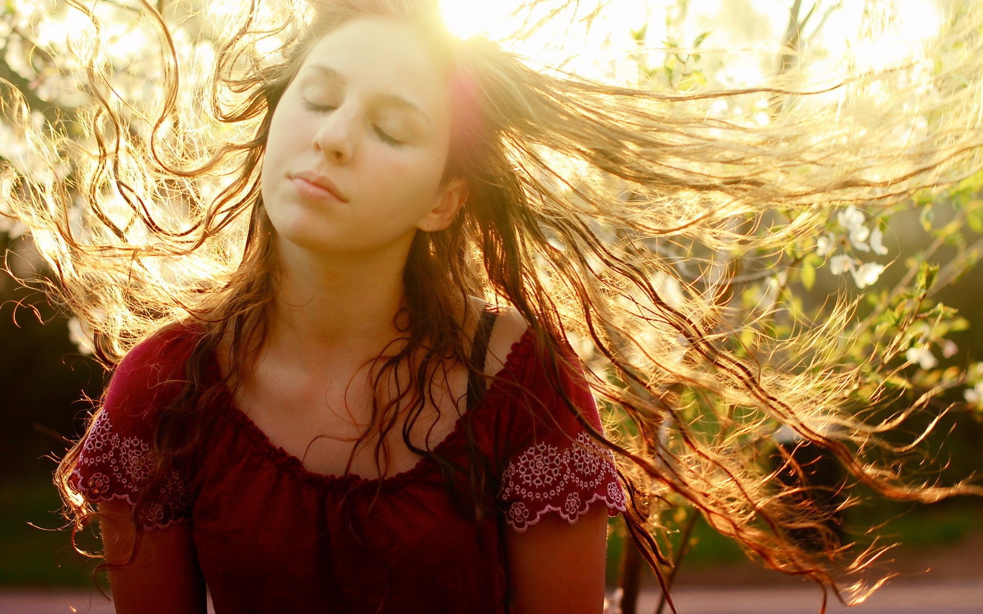 Ветер растрепал волосы девушки в красном платье