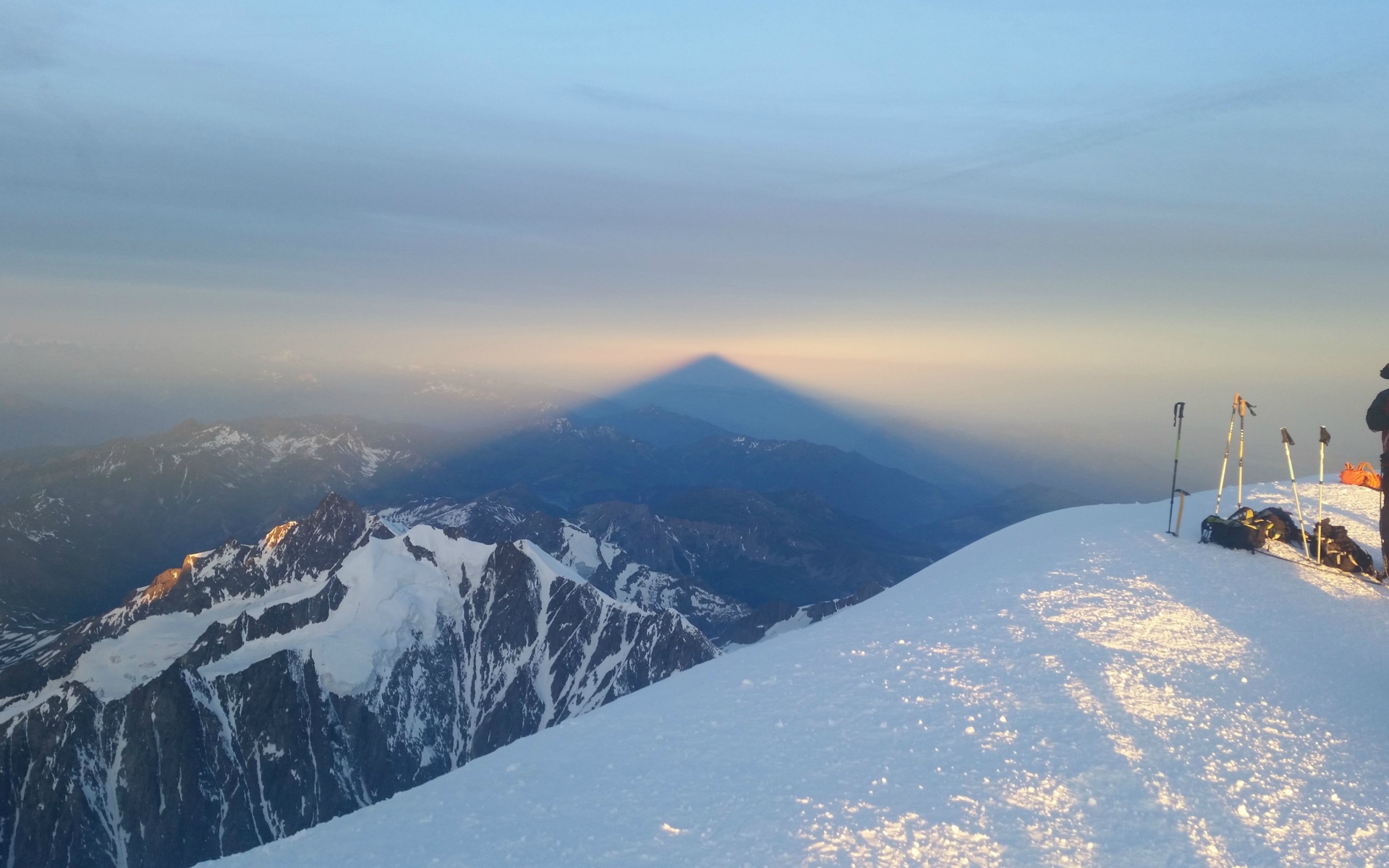 Лыжники на вершине горы перед закатом солнца