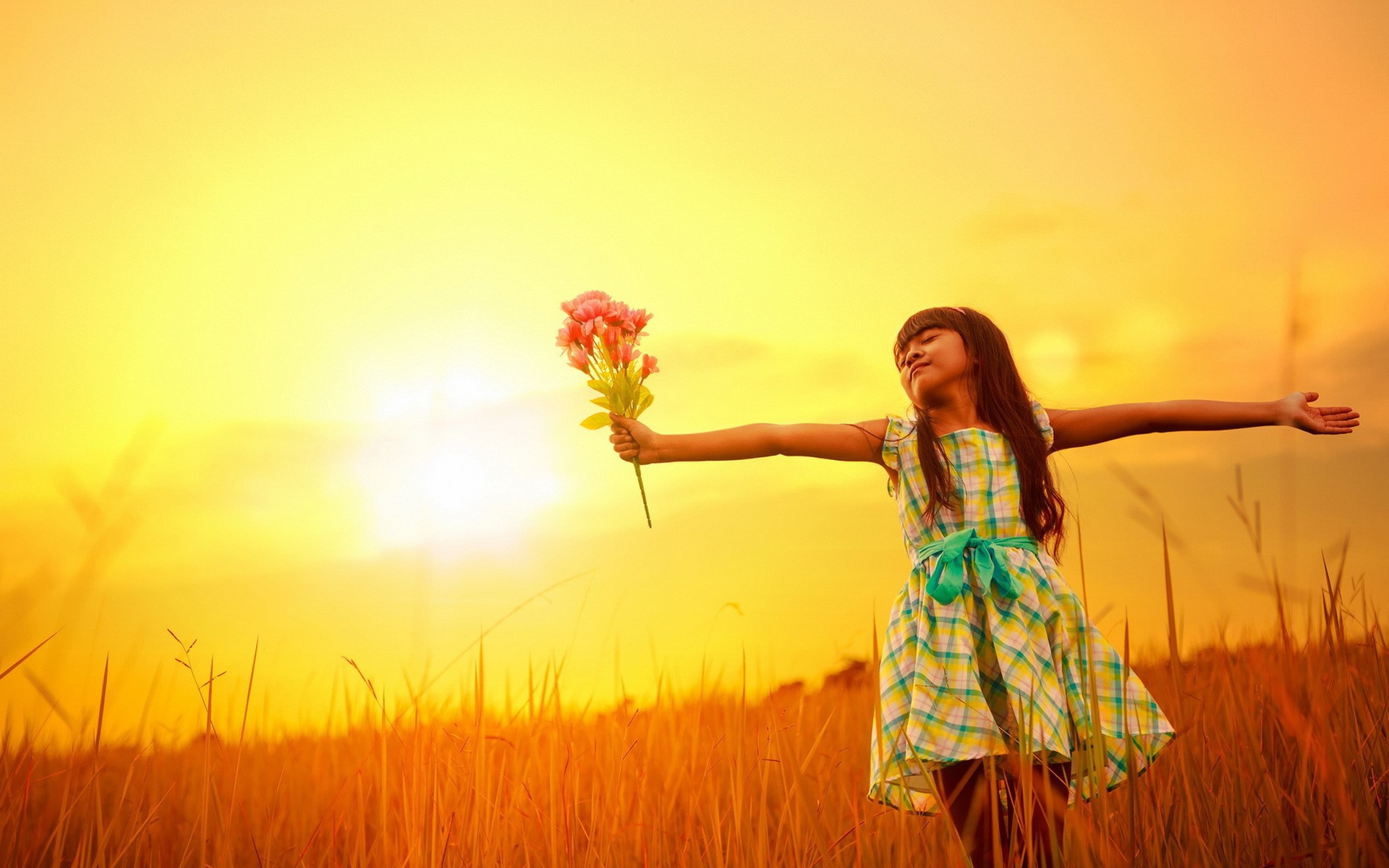 Девочка с букетом стоит в поле