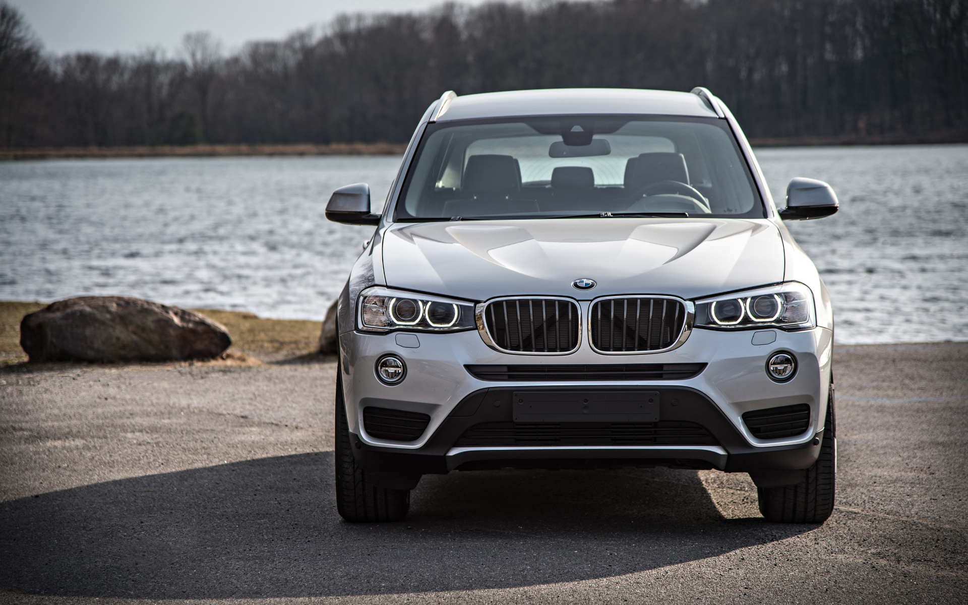 Серебристый автомобиль BMW X3 у водоема 