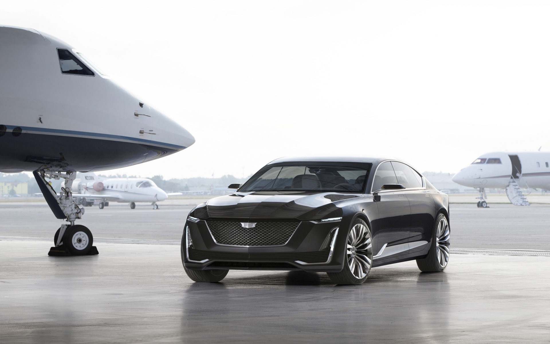 Черный стильный автомобиль Cadillac Escala на фоне самолетов