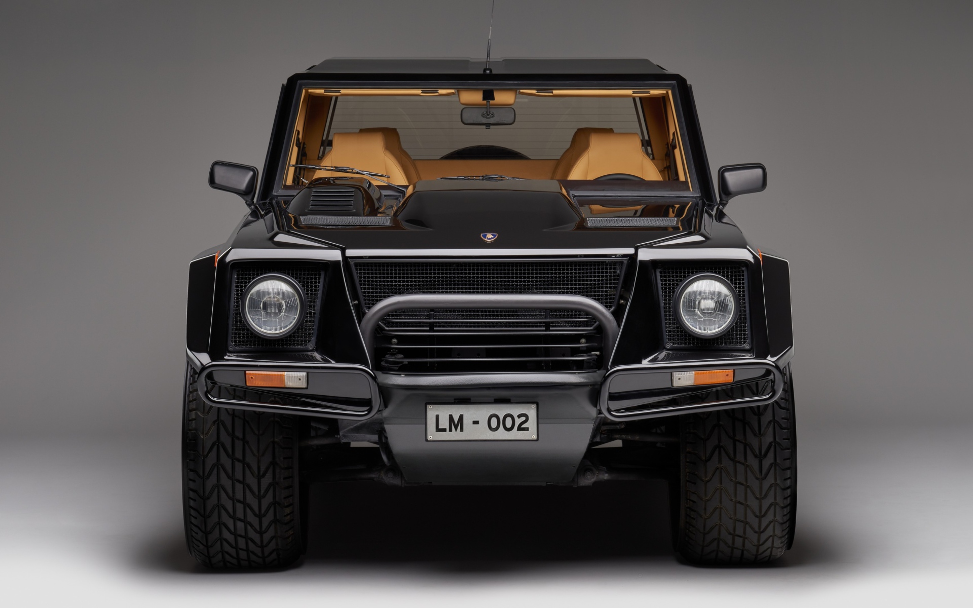 Черный автомобиль Lamborghini LM002 на сером фоне