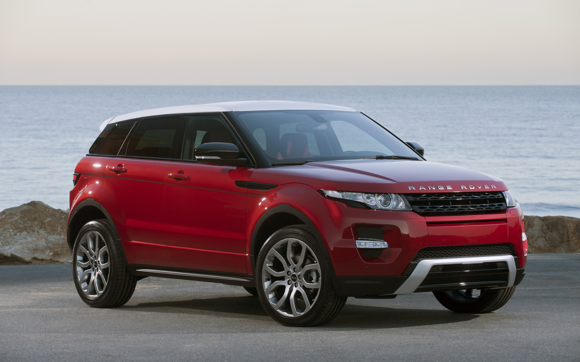 Красный автомобиль Land Rover Caractere на фоне океана