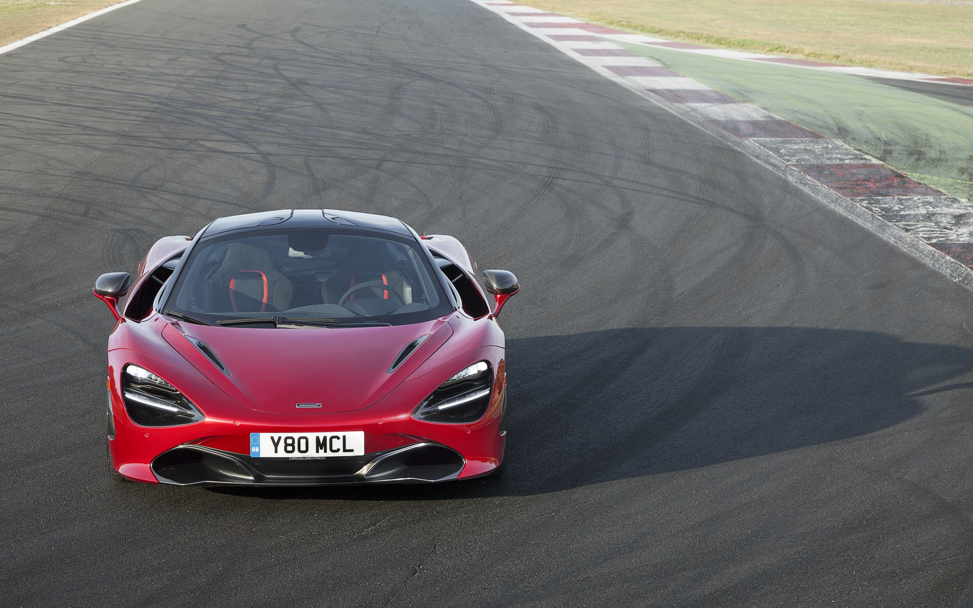 Красный гоночный автомобиль McLaren 720S на трассе 