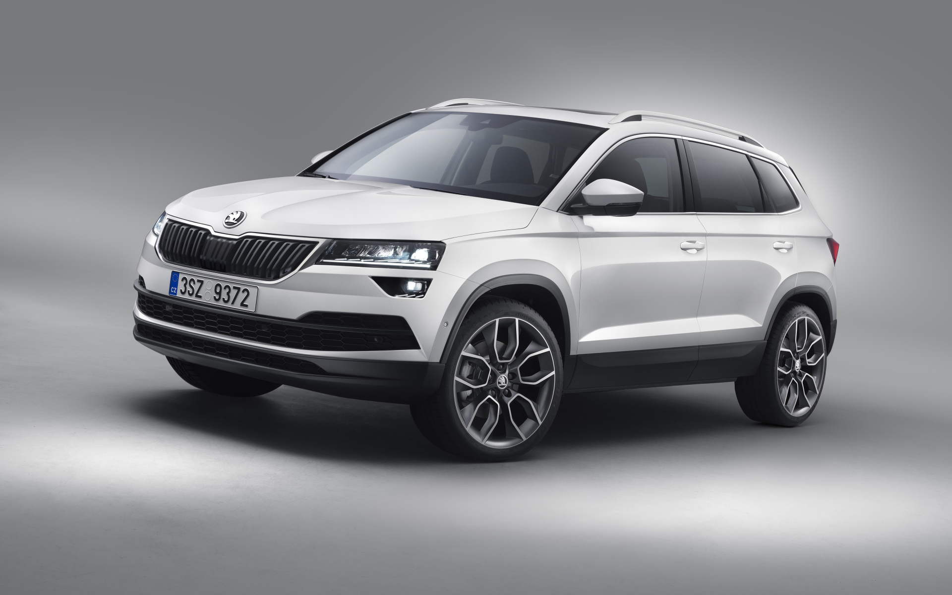 Белый внедорожник Škoda Karoq на сером фоне
