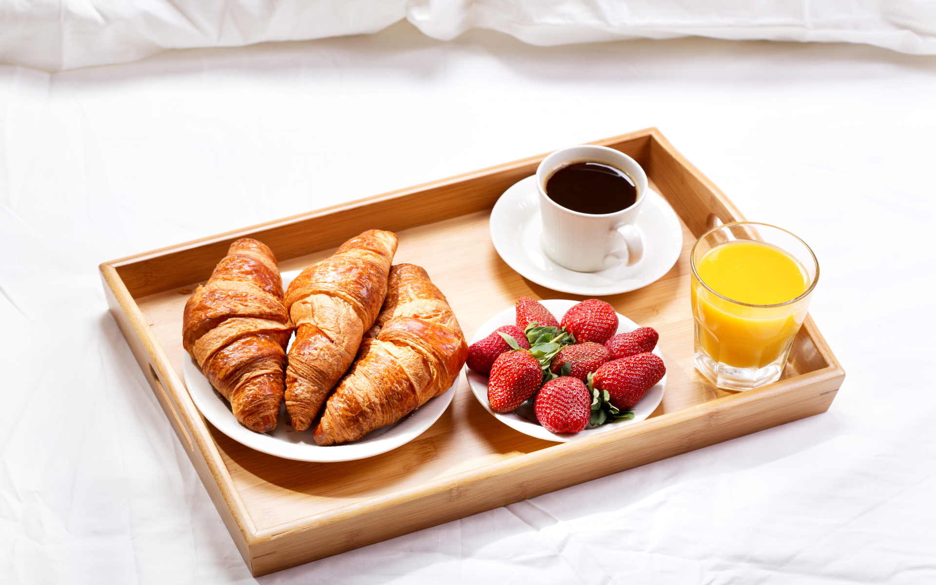 Круассаны, клубника, апельсиновый сок и кофе на завтрак