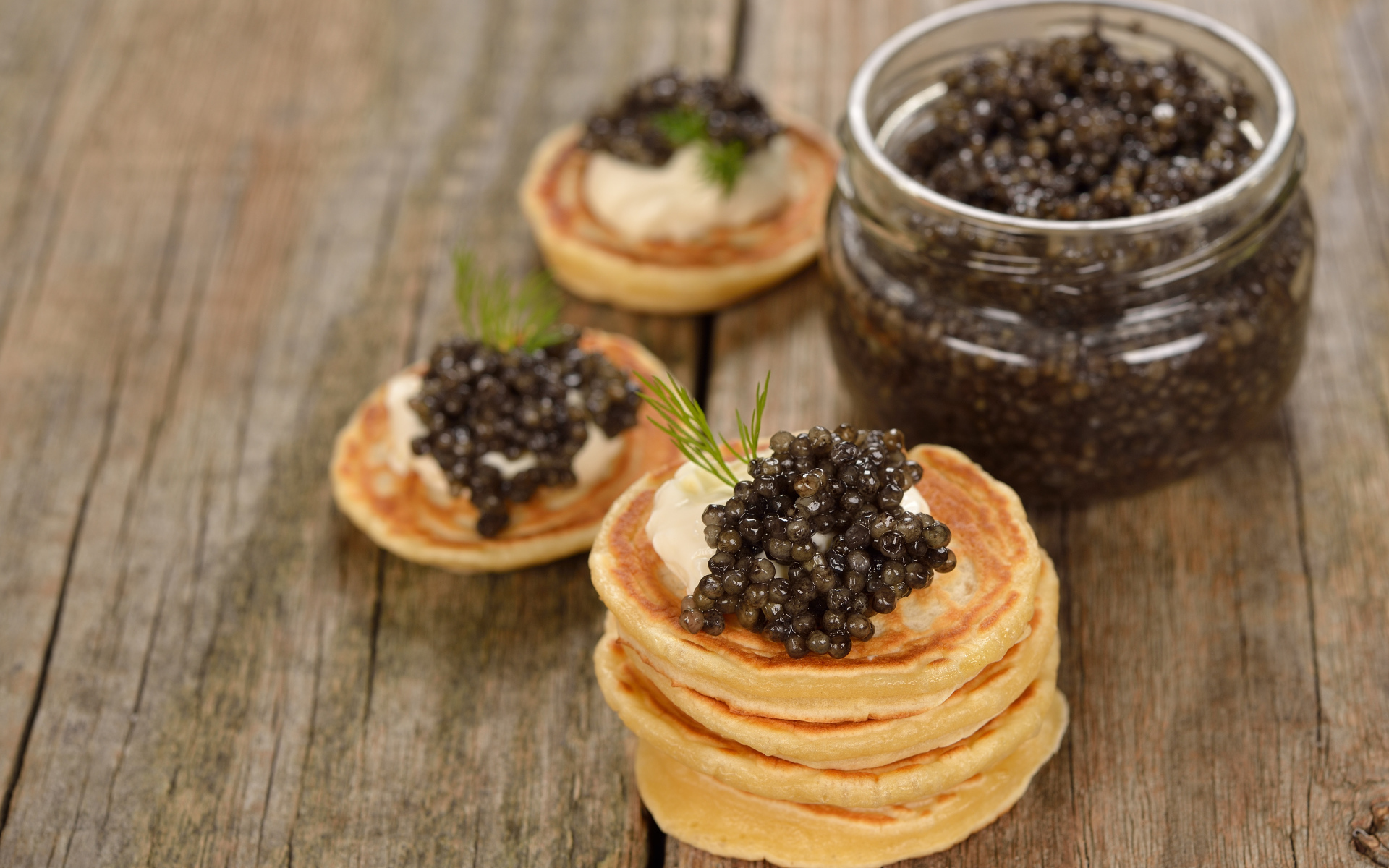 Оладьи с икрой и зеленью на столе