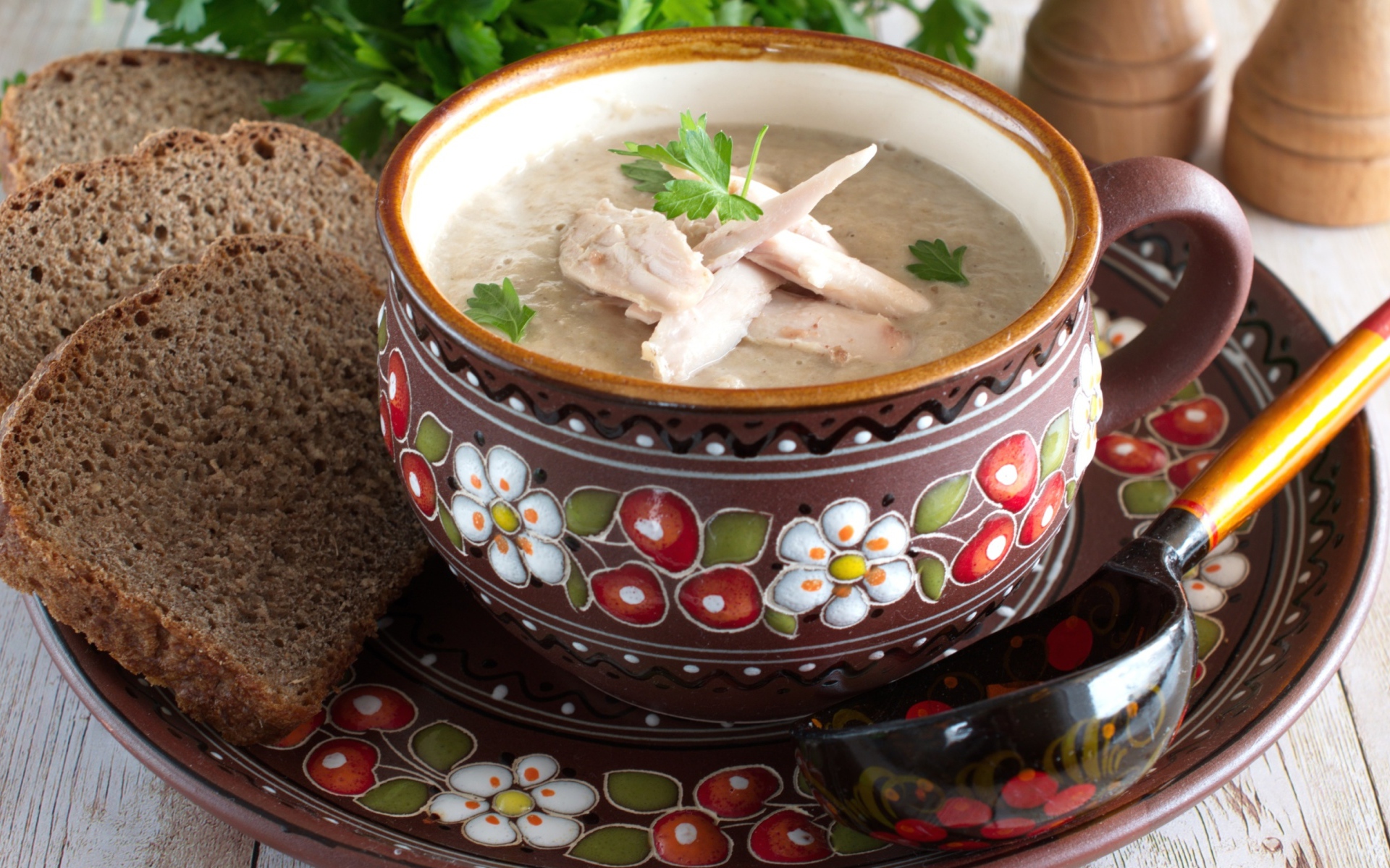 Суп с курицей в красивой тарелке на столе с черным хлебом