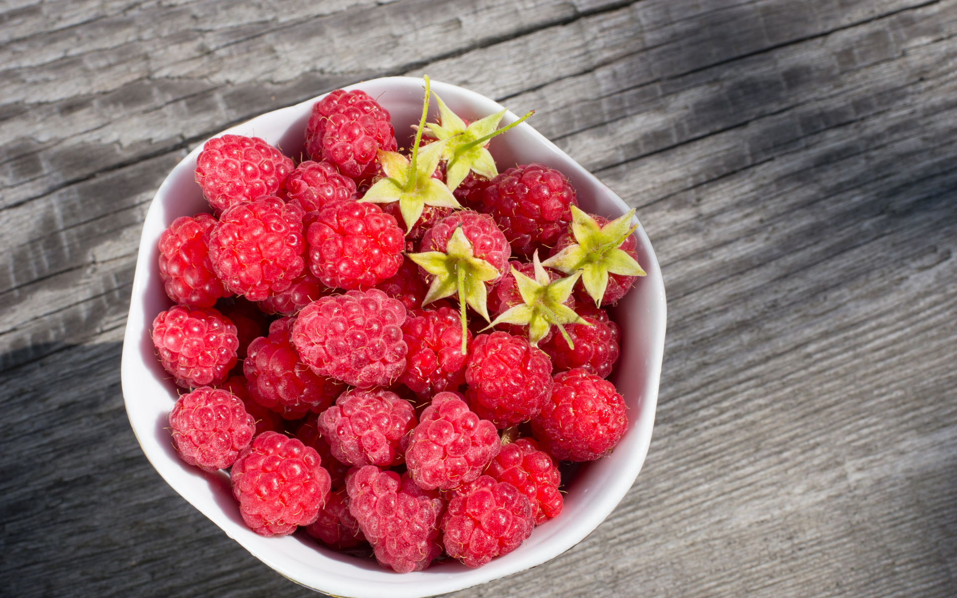 Аппетитная сочная свежая малина в белой тарелке 