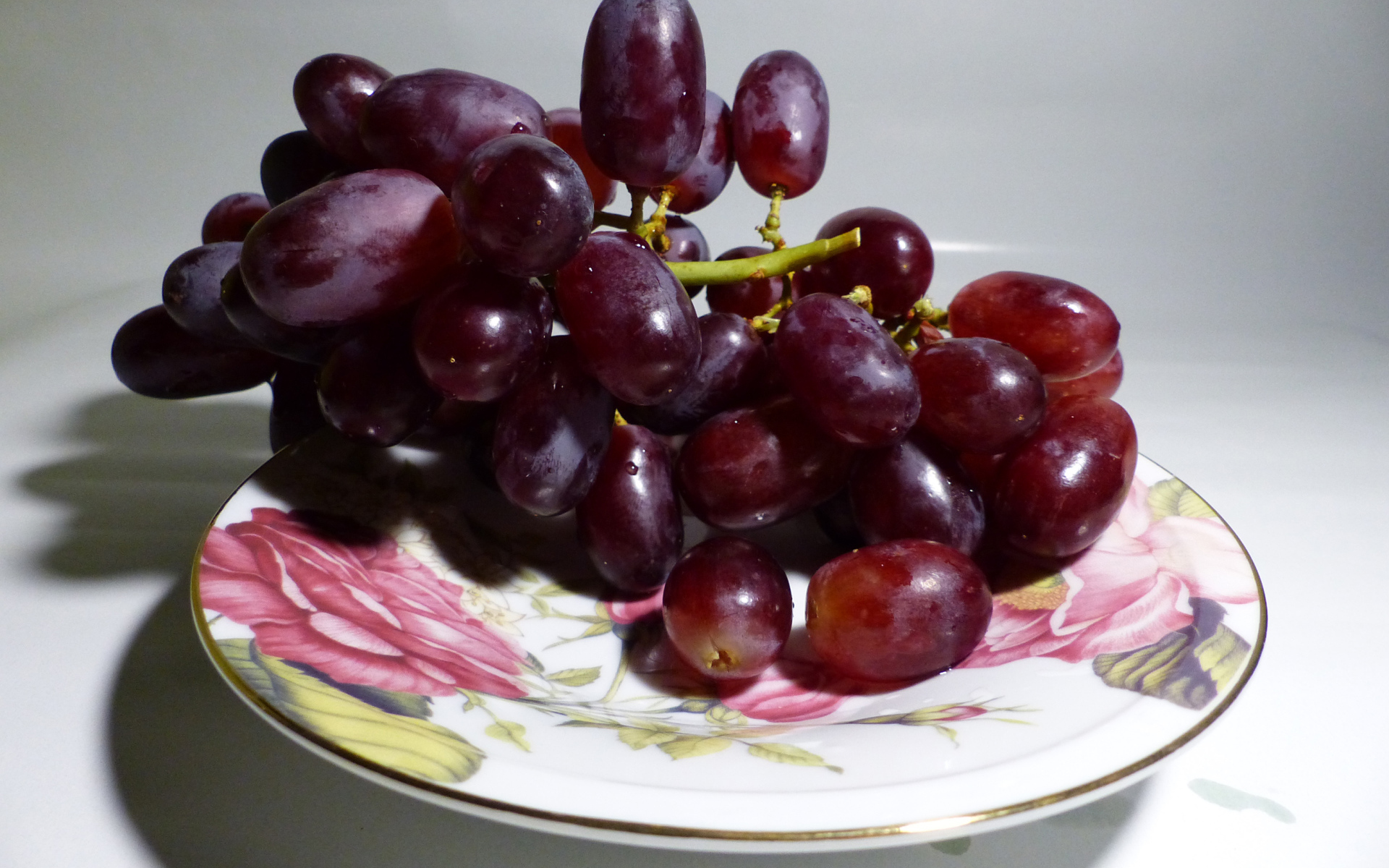 Розовый виноград на тарелке крупным планом