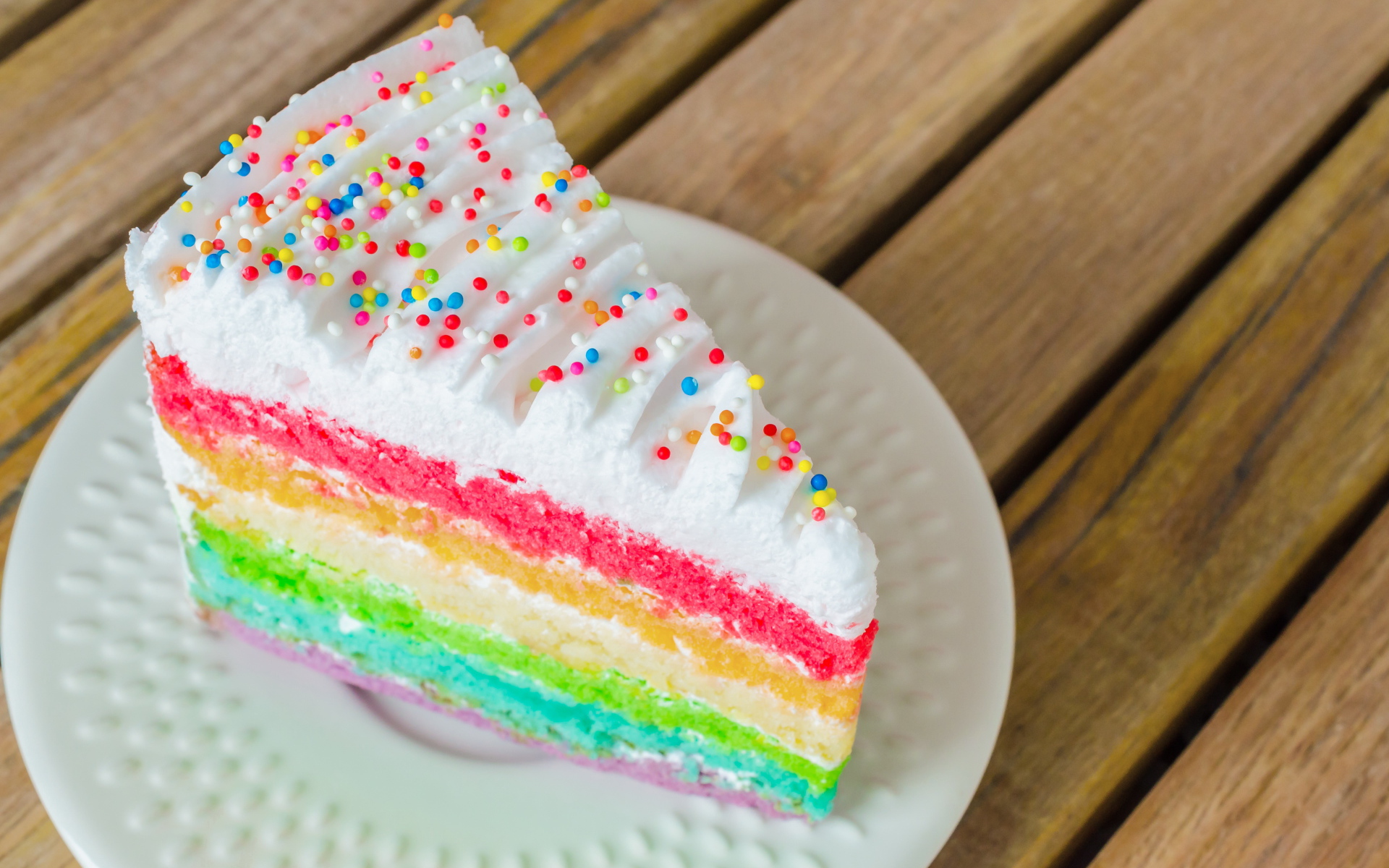 Кусок разноцветного торта на белой тарелке