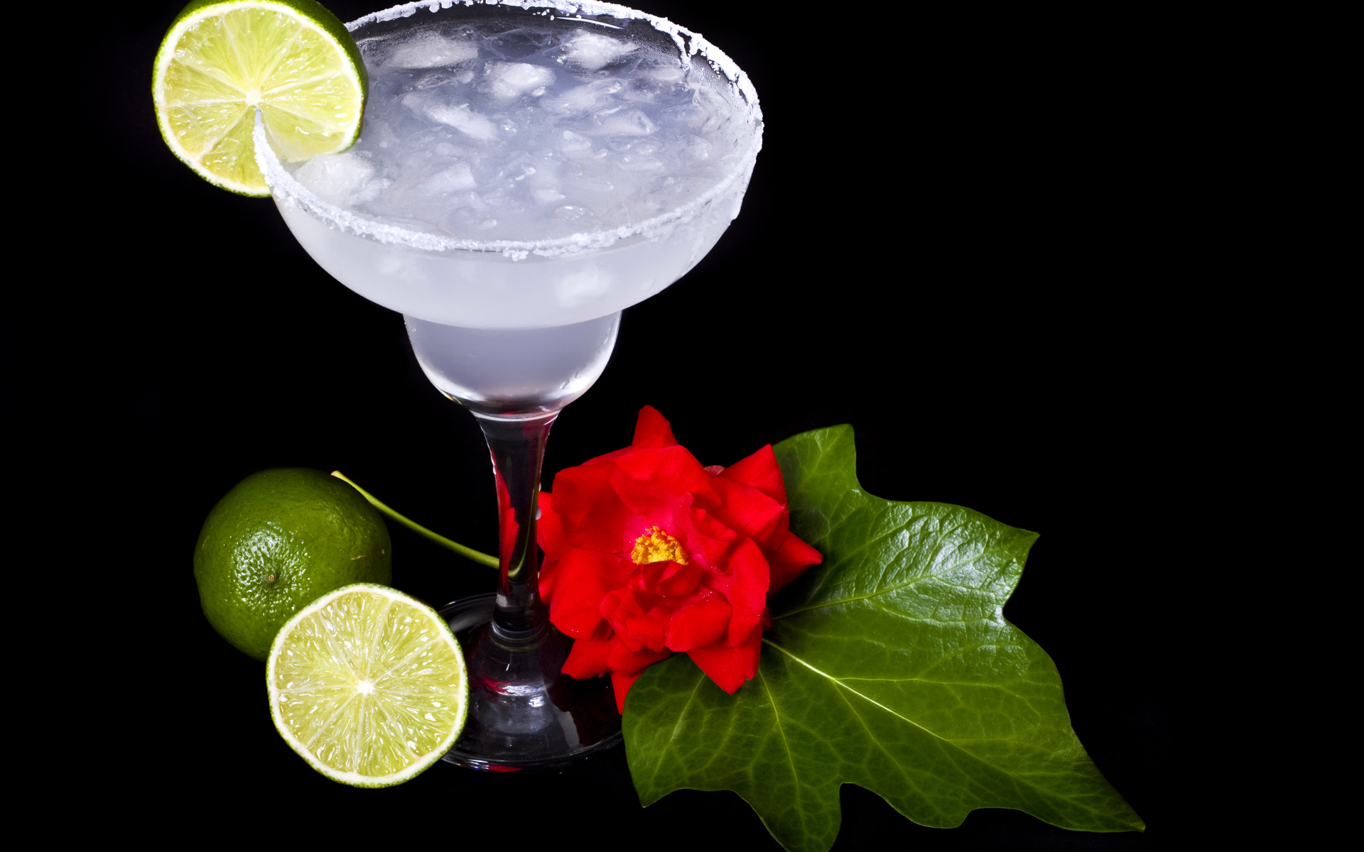 Бокал коктейля со льдом и лаймом на черном фоне