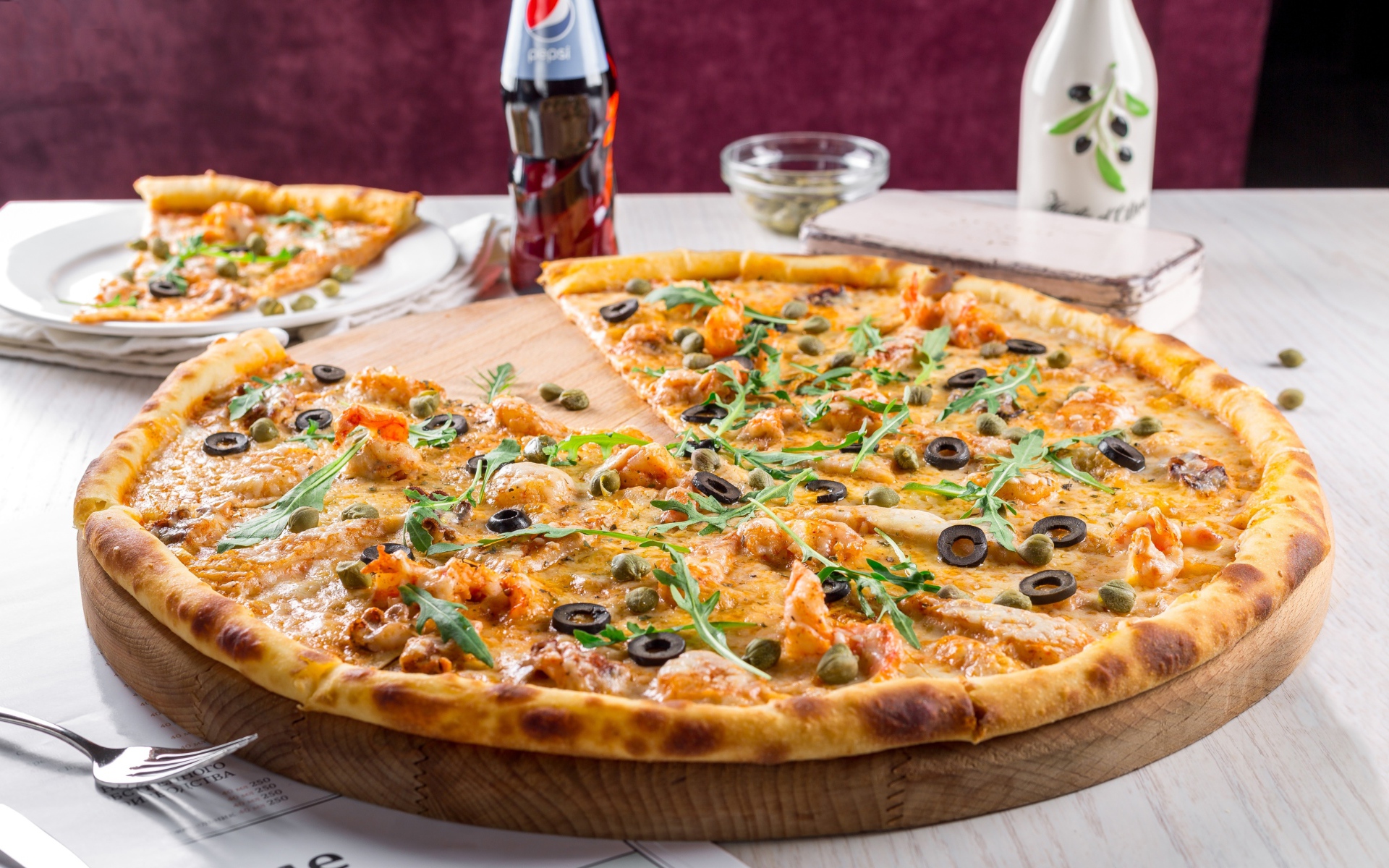 Пицца с оливками на столе с бутылкой пепси