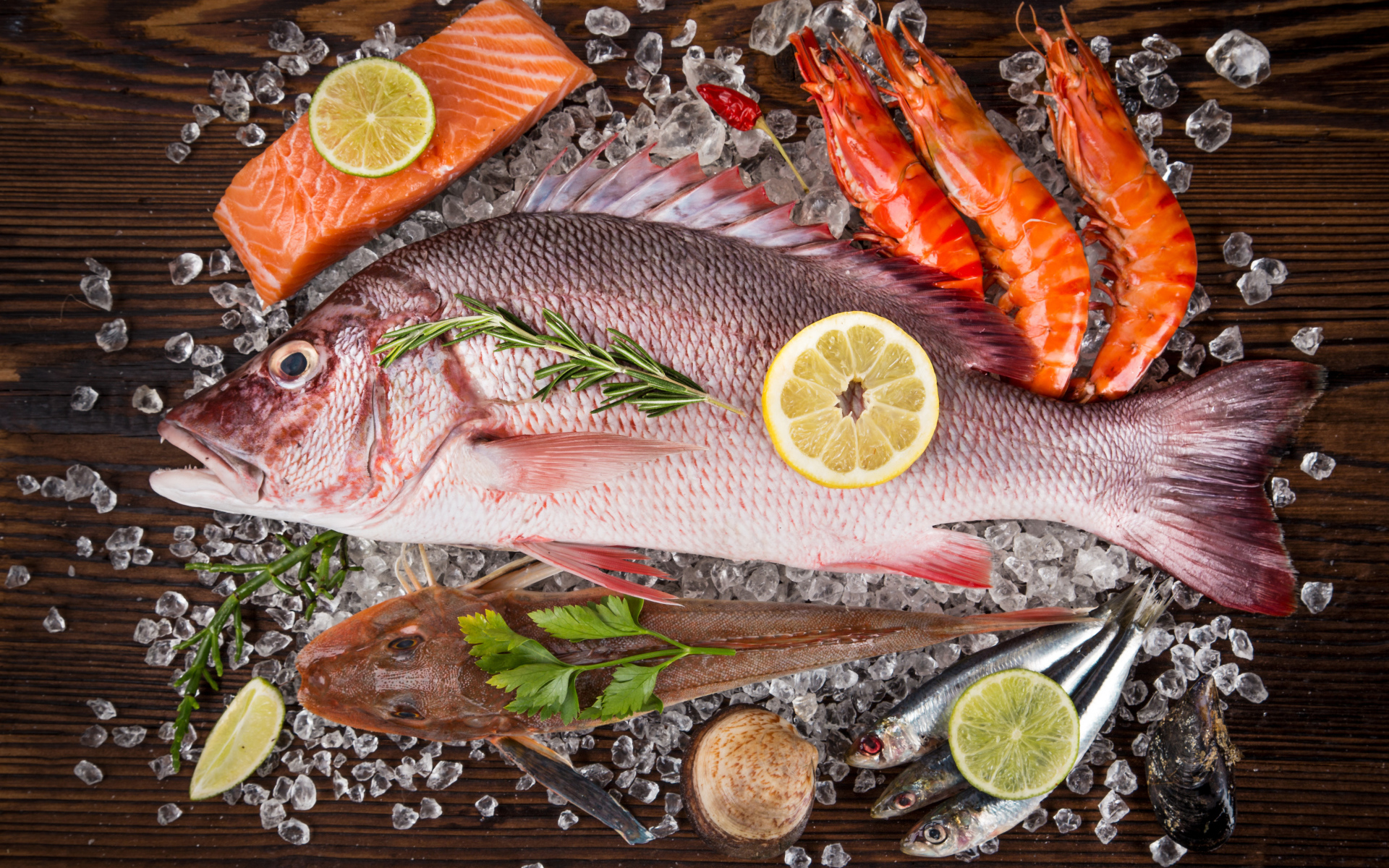 Свежая рыба с креветками и кусочками лимона лежит на кусочках льда