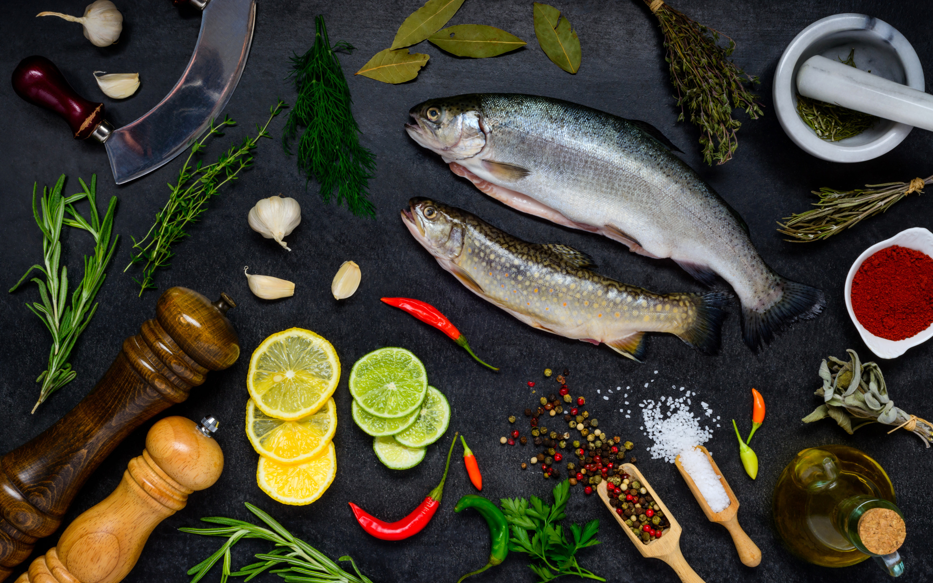 Сырая рыба на столе со специями и лимонами
