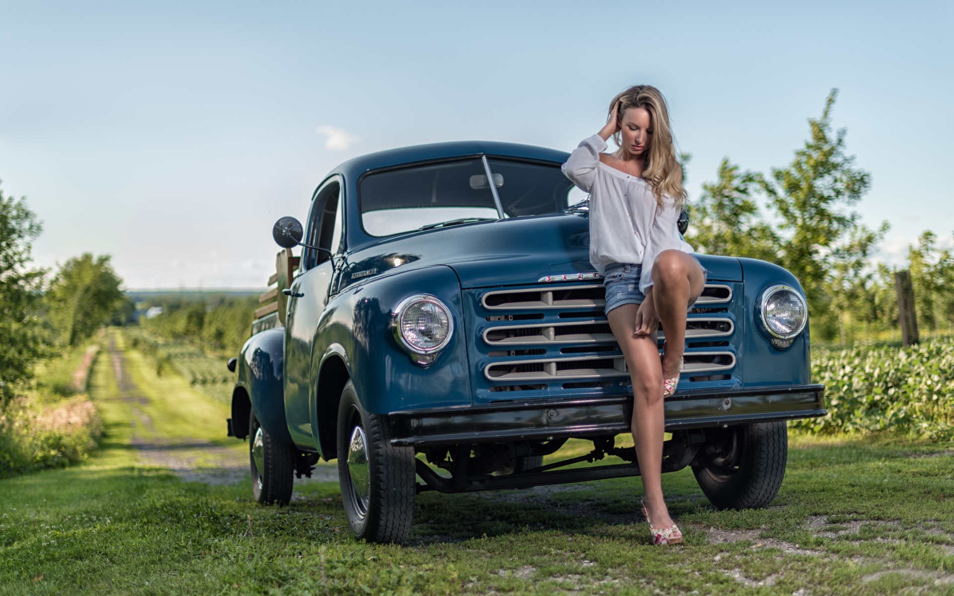 Молодая девушка стоит рядом с зеленым автомобилем Studebaker Pickup, 1953 года