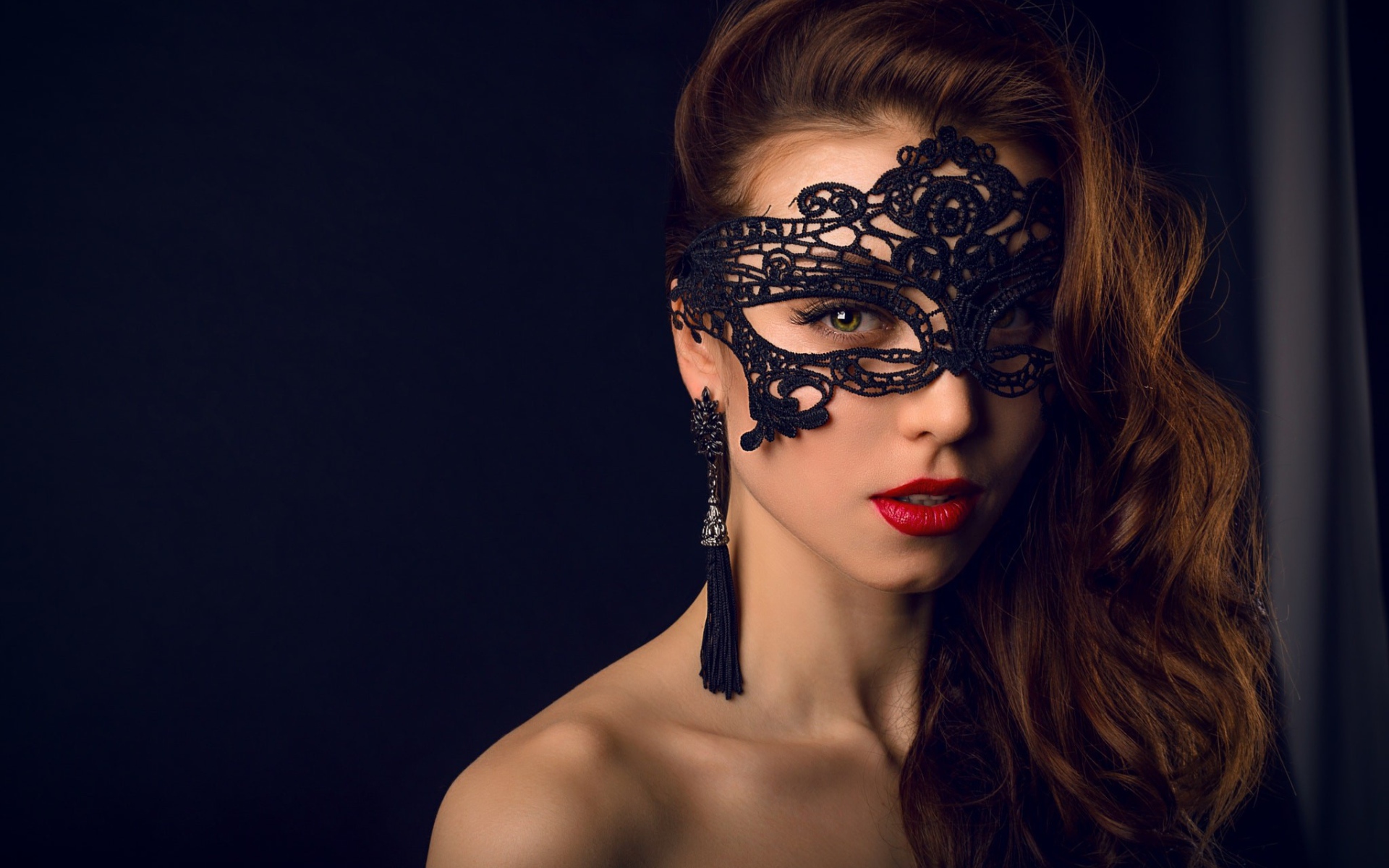 Красивая брюнетка с черной маской на лице 