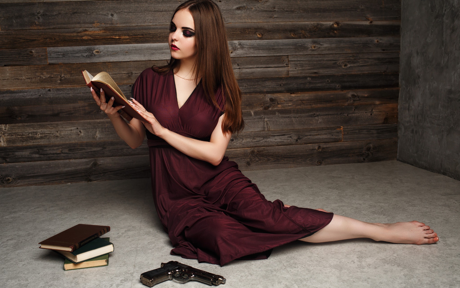 Красивая девушка в бордовом платье с книгами