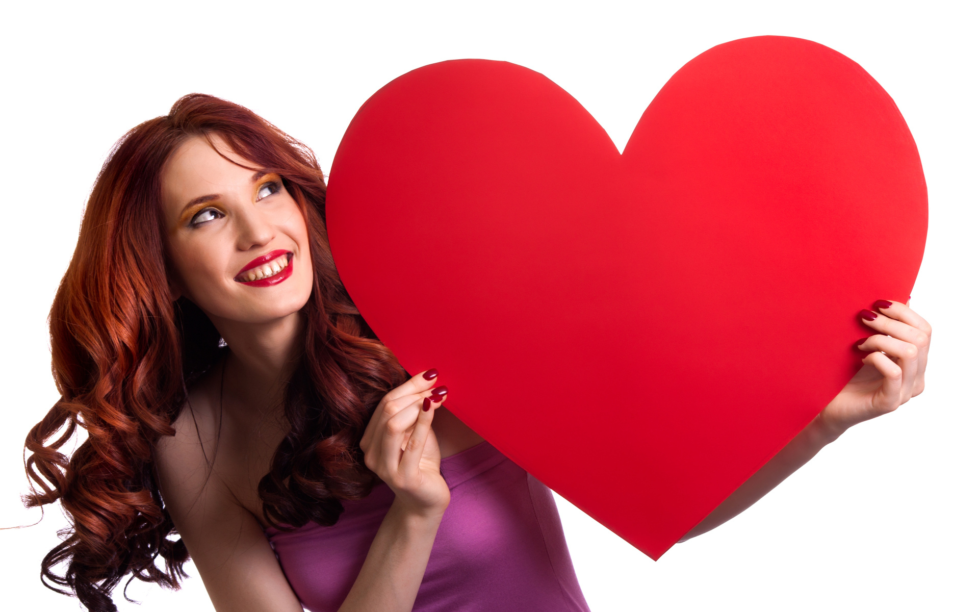 Красивая улыбающаяся девушка с большим красным сердцем в руках