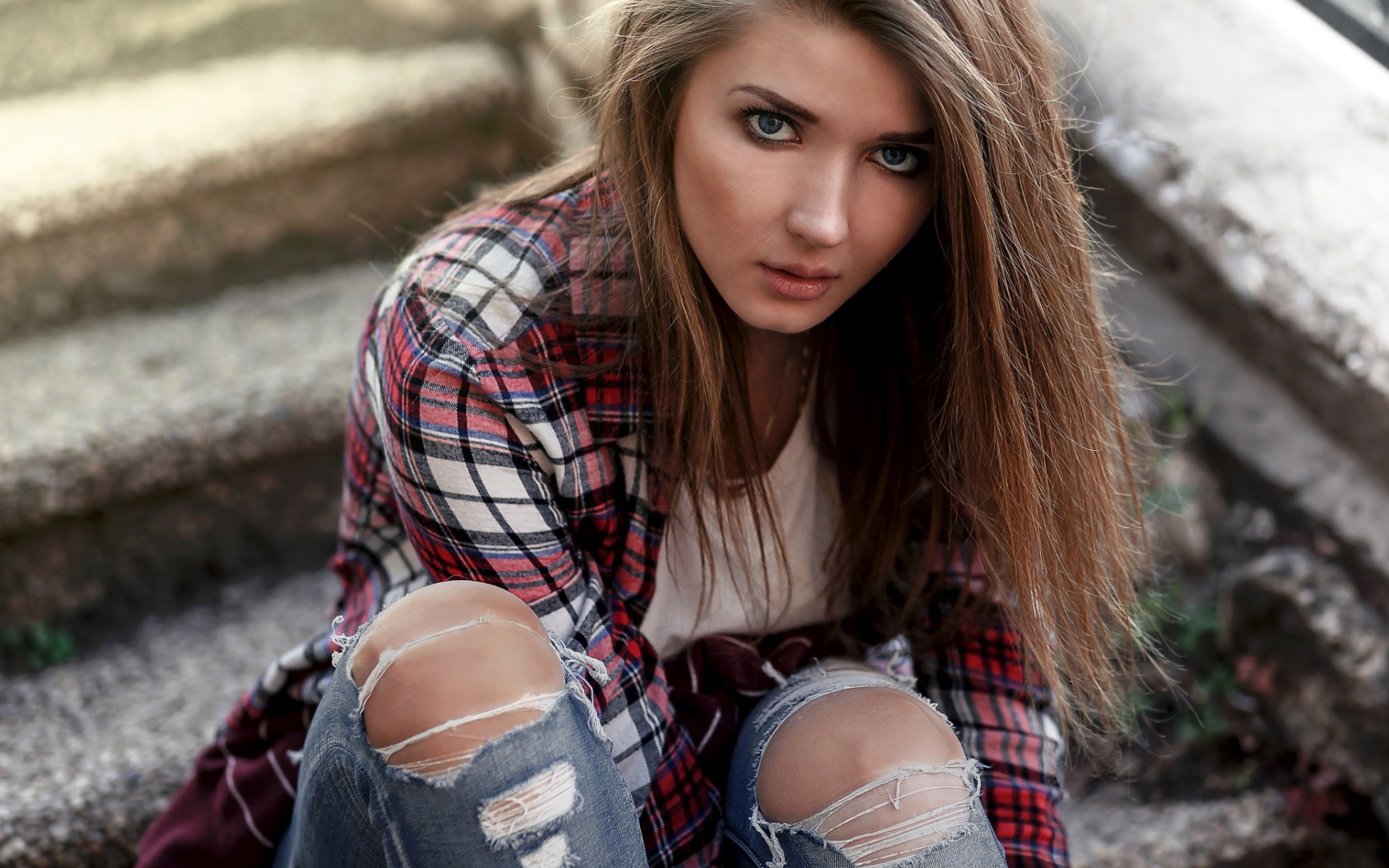 Голубоглазая девушка брюнетка в модных джинсах 