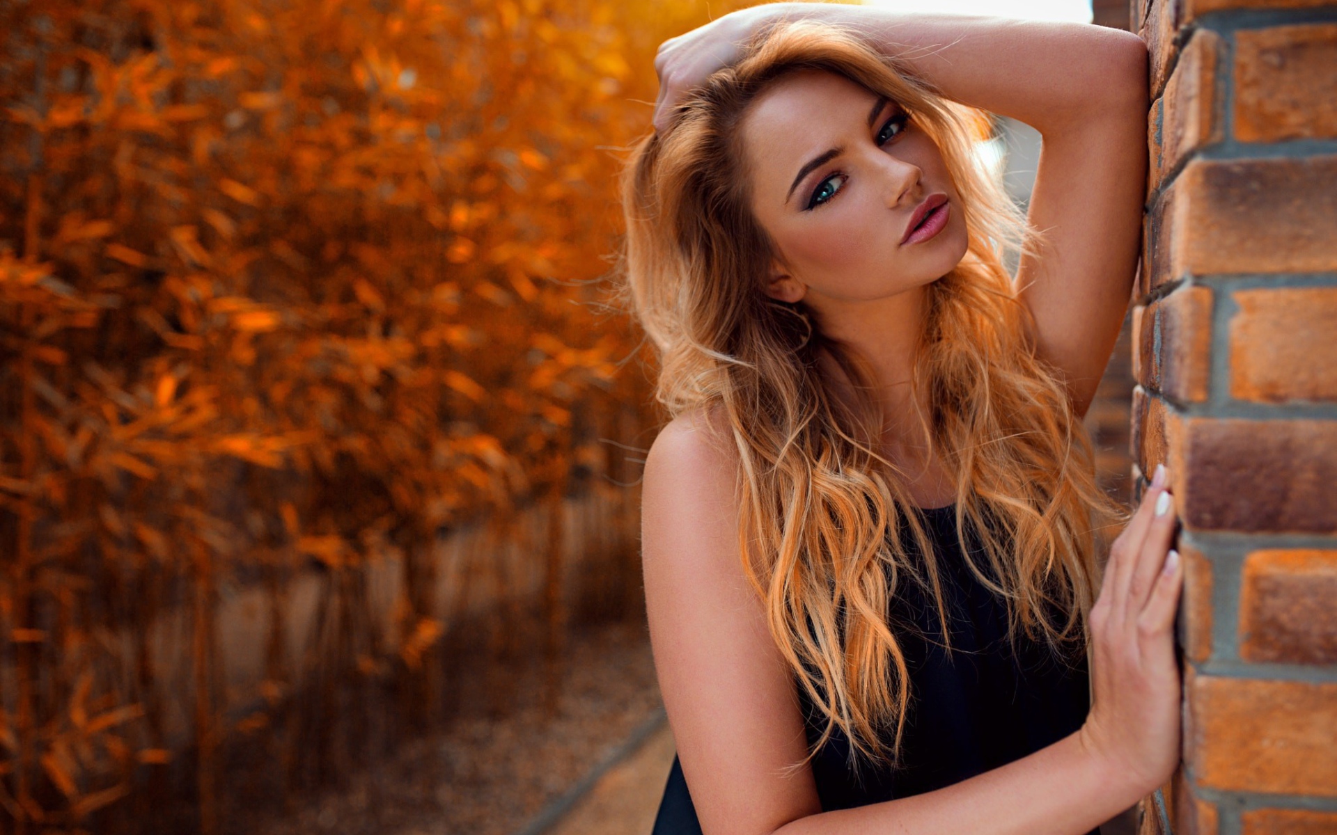 Голубоглазая девушка блондинка у стены 