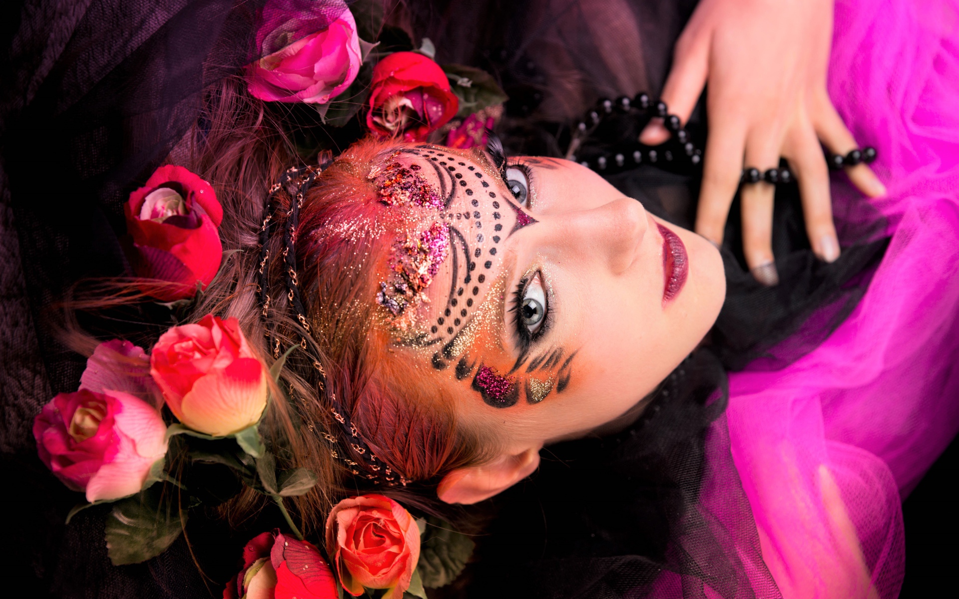 Девушка с блестящим ярким макияжем и розами в волосах