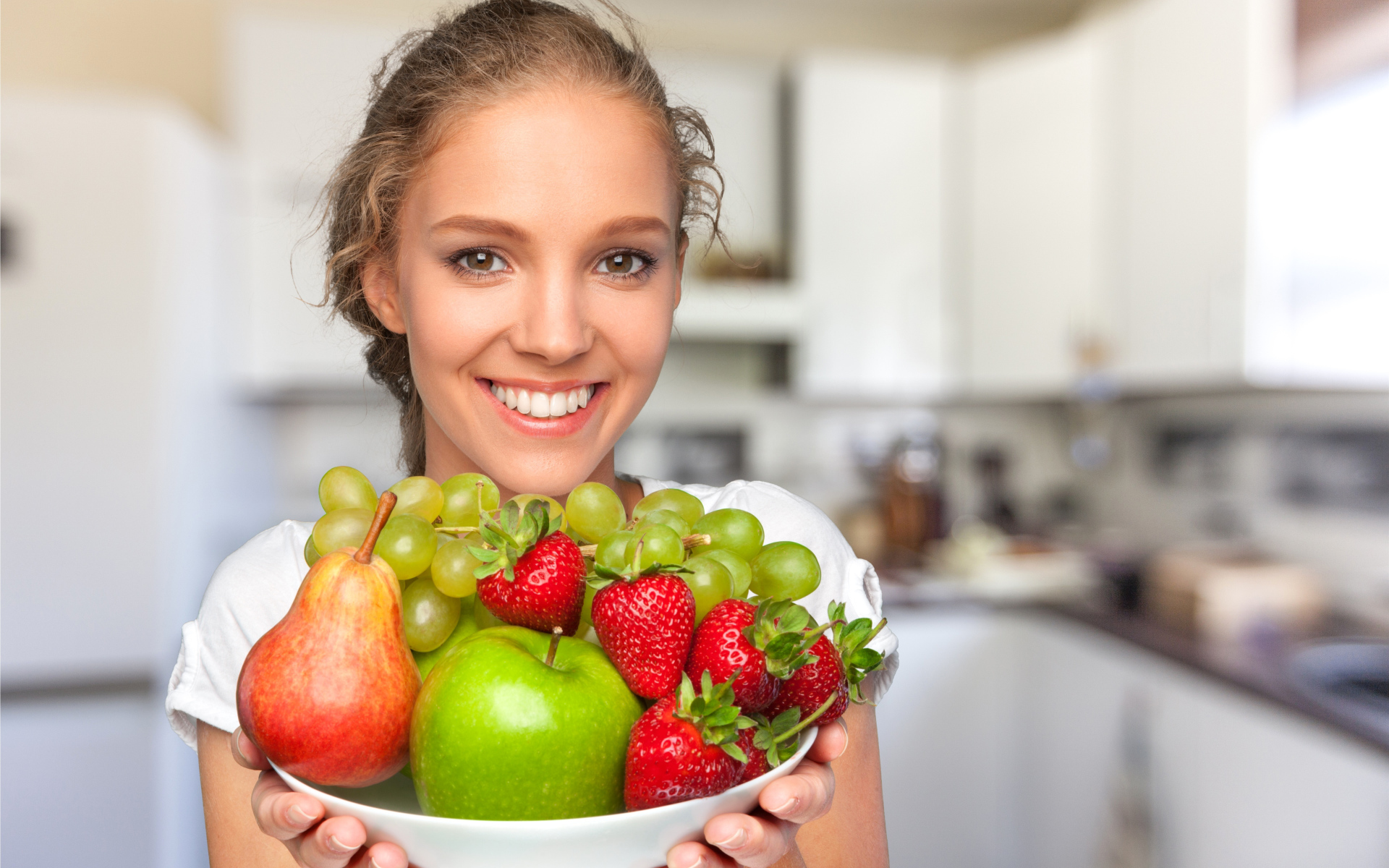 Улыбающаяся девушка со свежими фруктами 