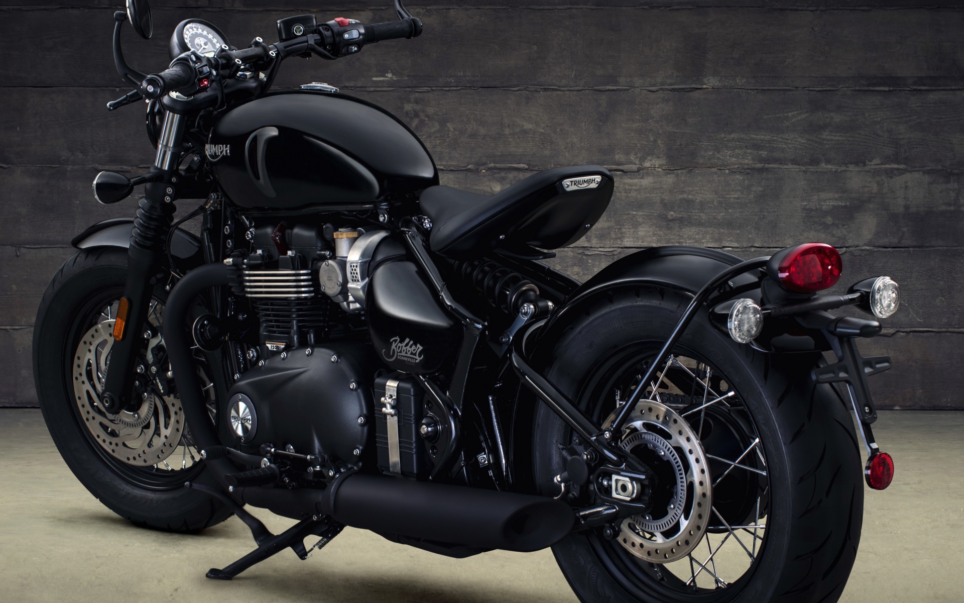 Черный мотоцикл Triumph Bonneville Bobber, 2018 вид сзади