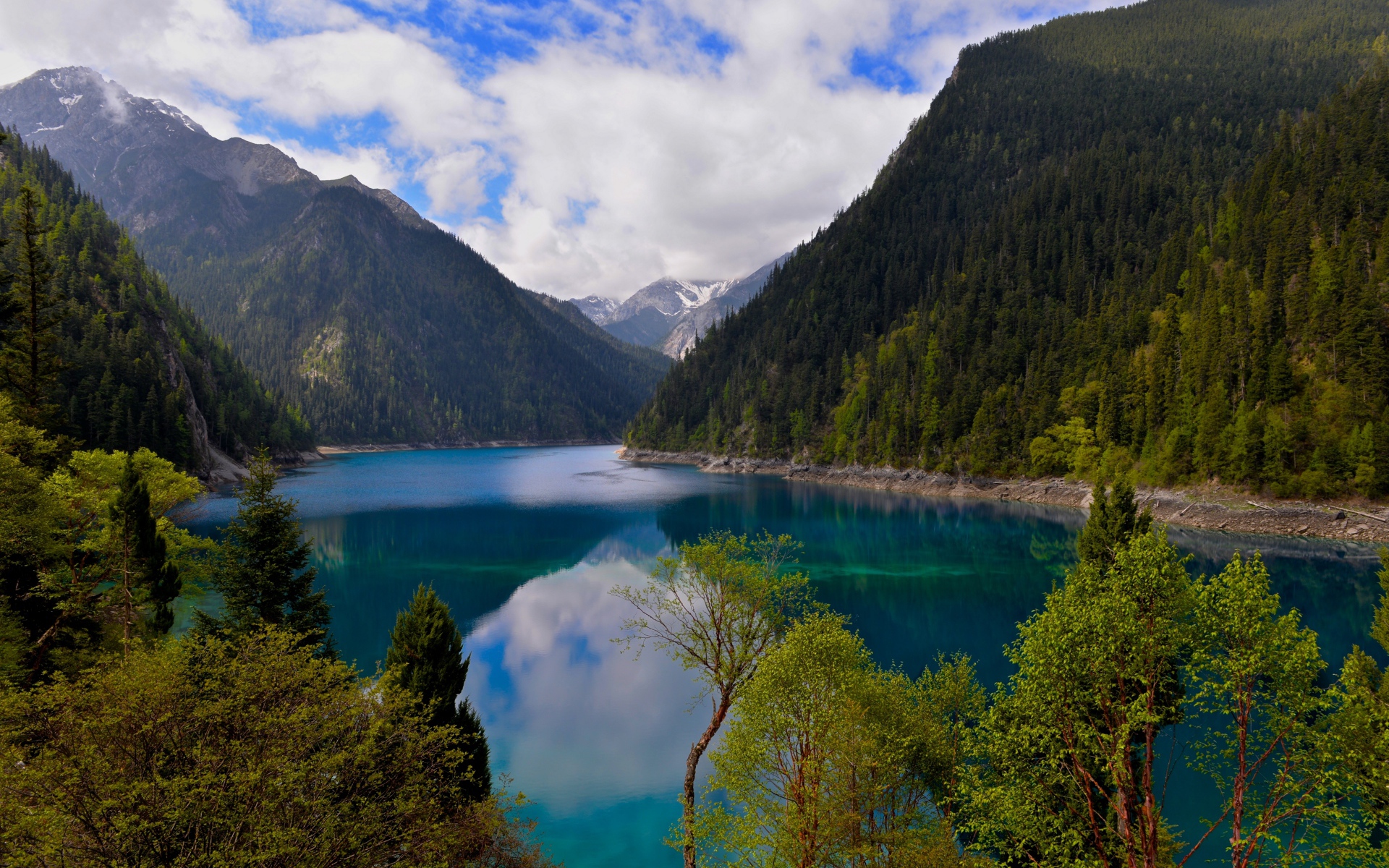 Красивое озеро у покрытых лесом гор в парке Цзючжайгоу, Китай