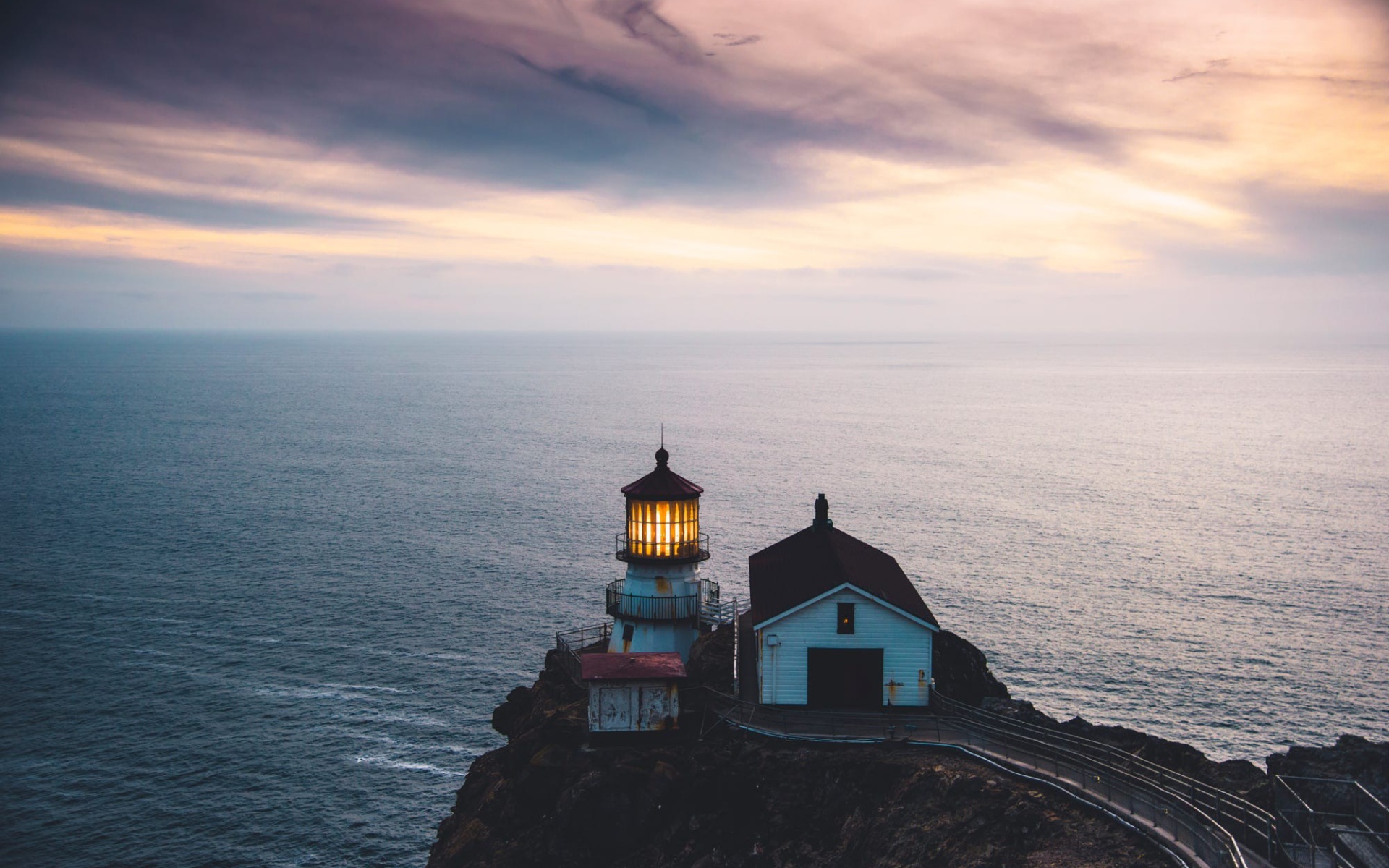 Маяк на скале на фоне горизонта океана 