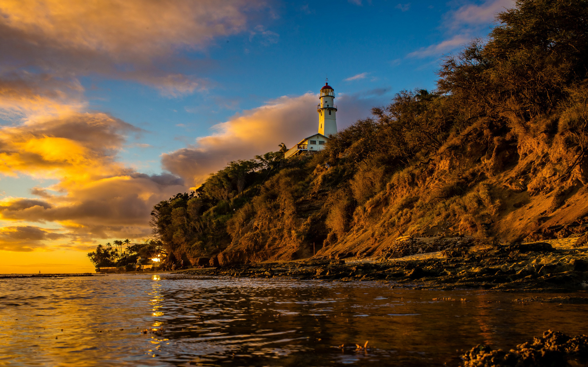 Маяк на склоне скалы на закате 