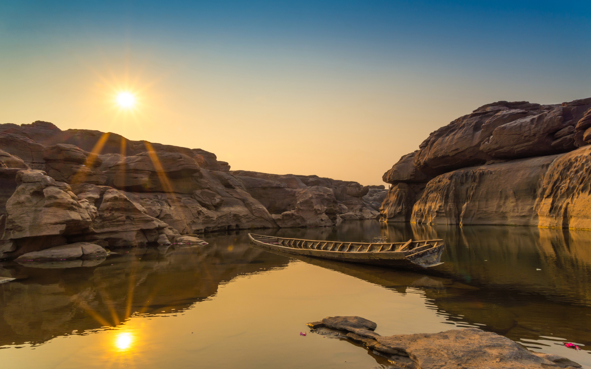 Лодна на озере между скал на рассвете