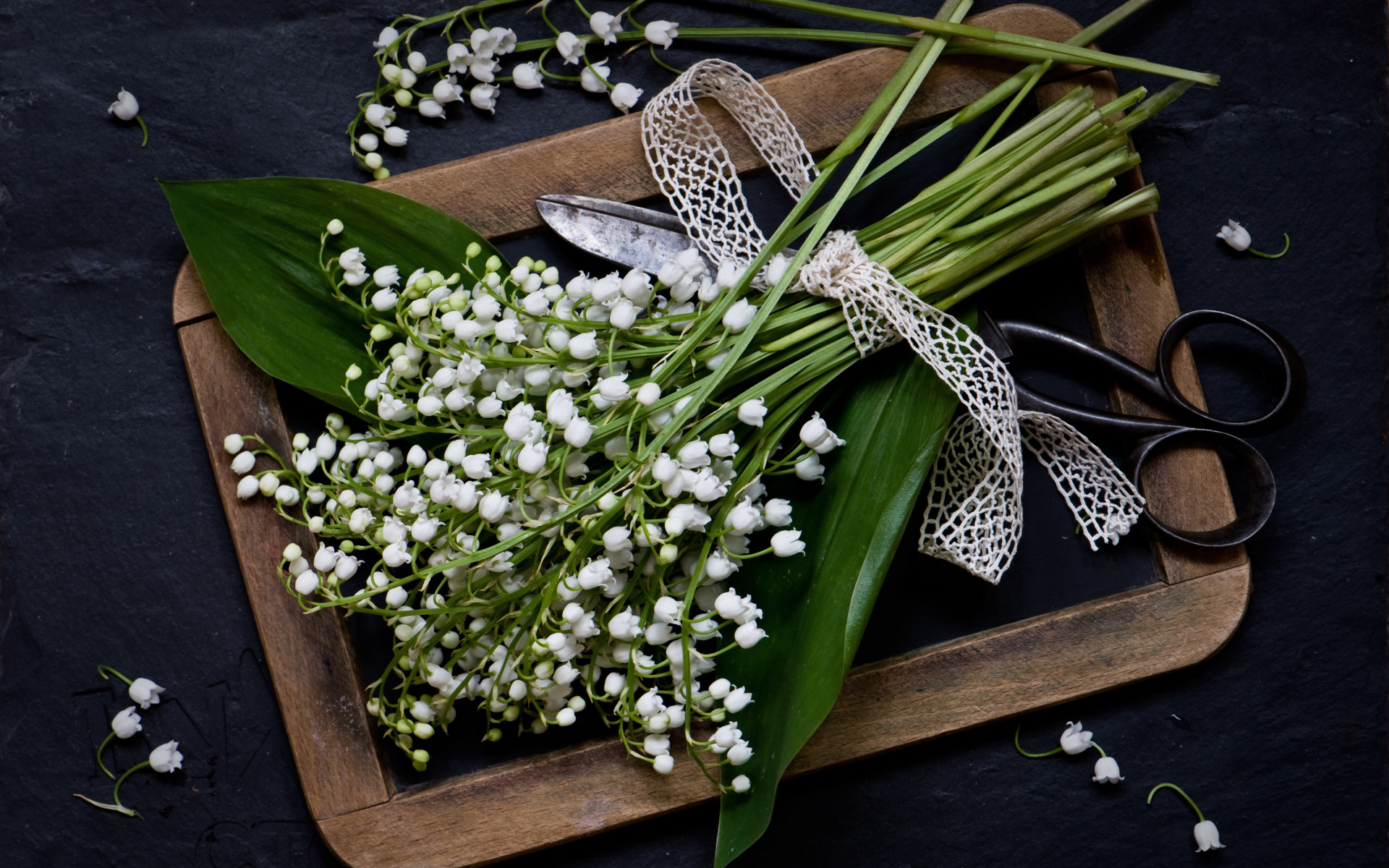 Букет белых ландышей с ножницами на столе