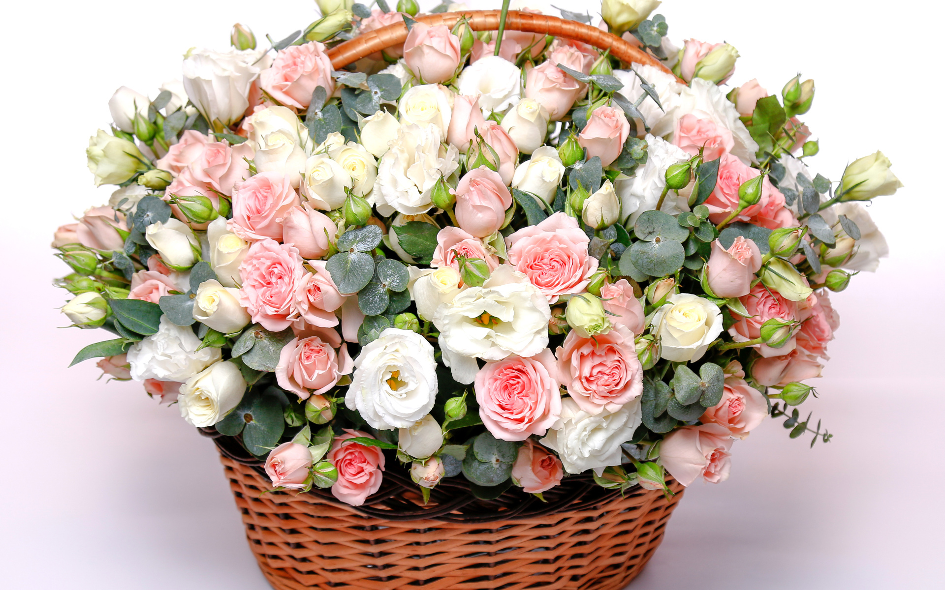Корзина с красивым букетом цветов роз, эустомы на розовом фоне