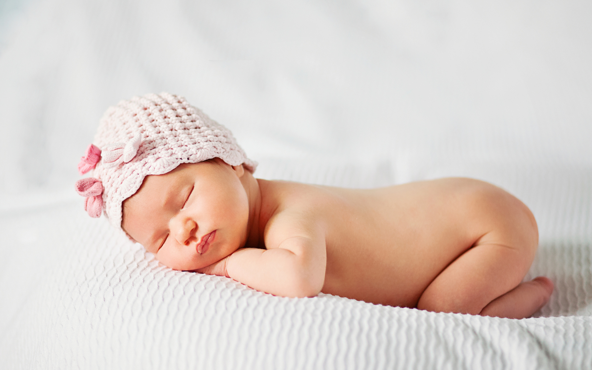 Спящий младенец девочка в розовой шапке