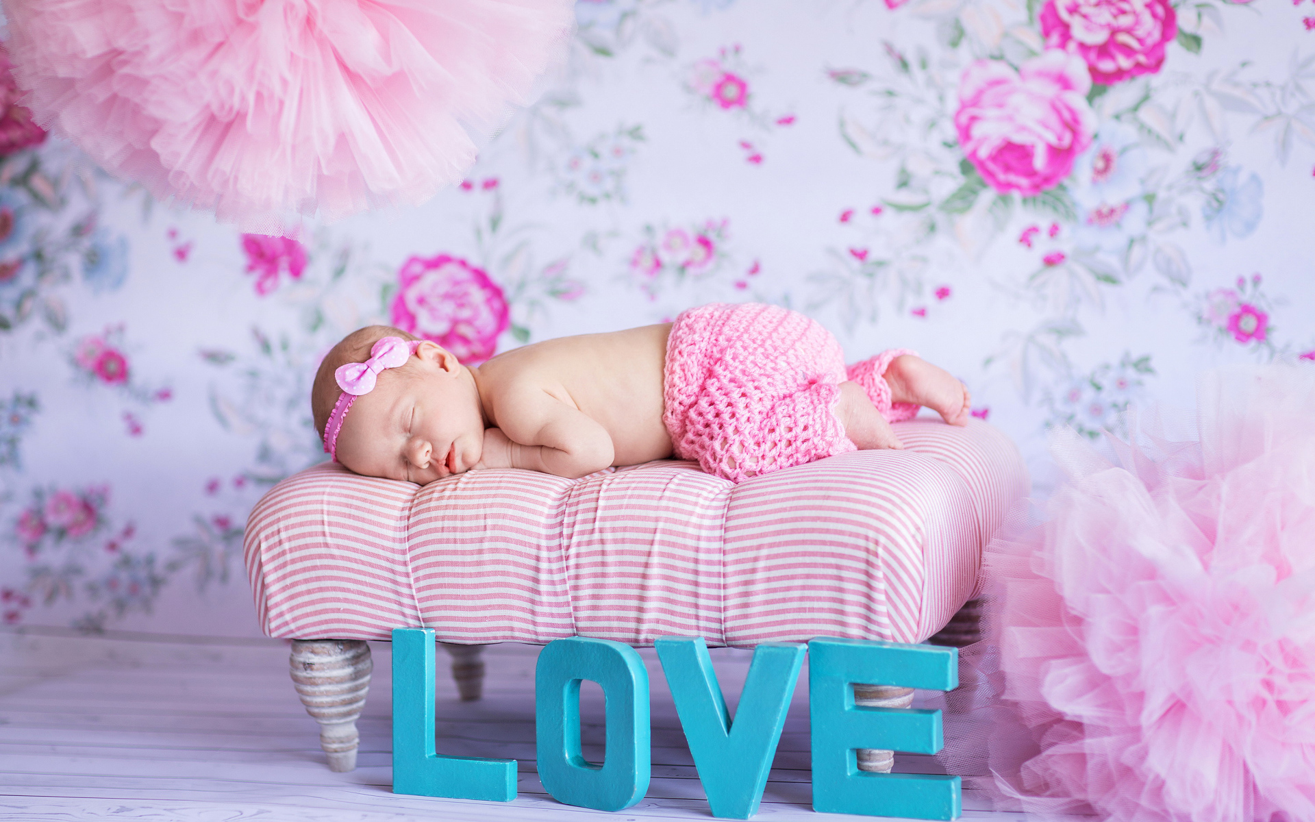 Спящий грудной ребенок в розовом костюме и надписью love