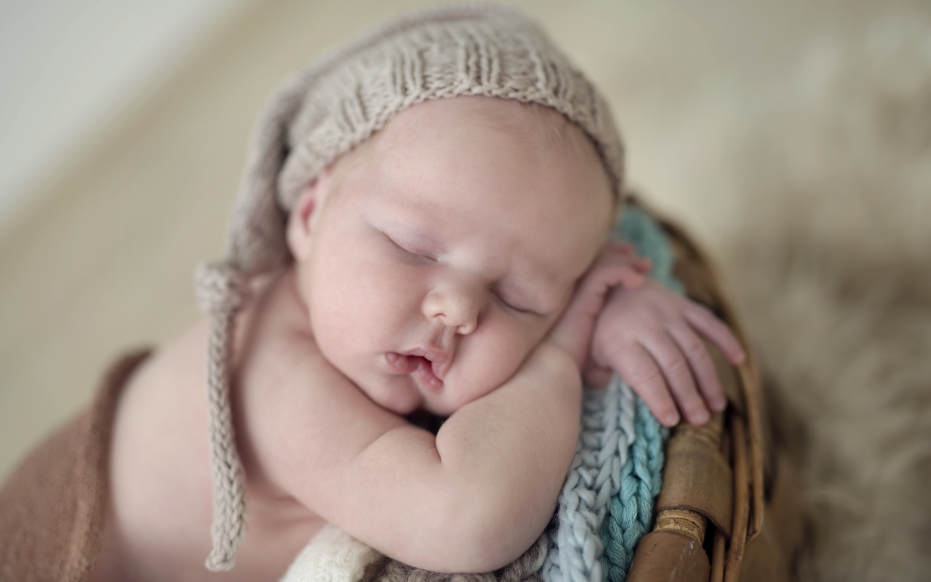 Маленький грудной ребенок спит в вязаной шапке