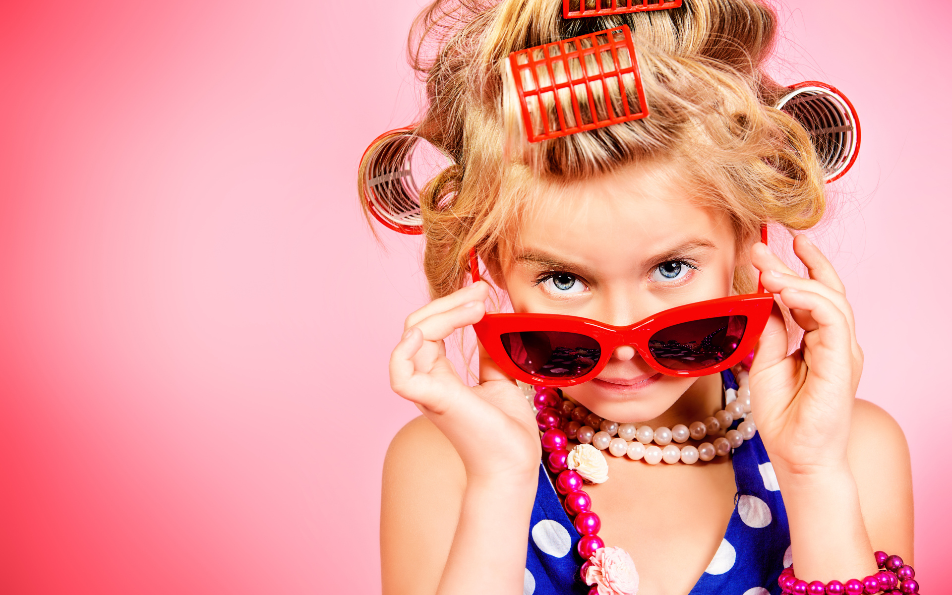Гламурная девочка в больших красных очках и бигудями на голове